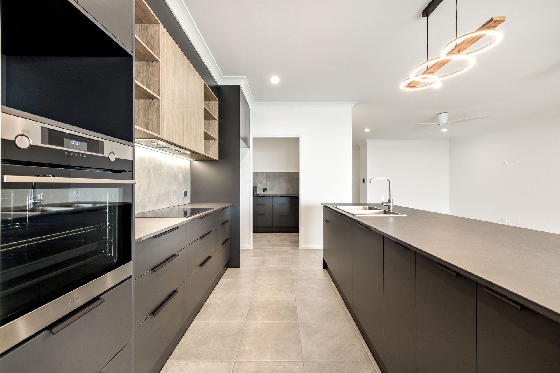 Modern Kitchen With Dark Charcoal Cabinetry — Ashlee Jones Homes in Gordonvale, QLD