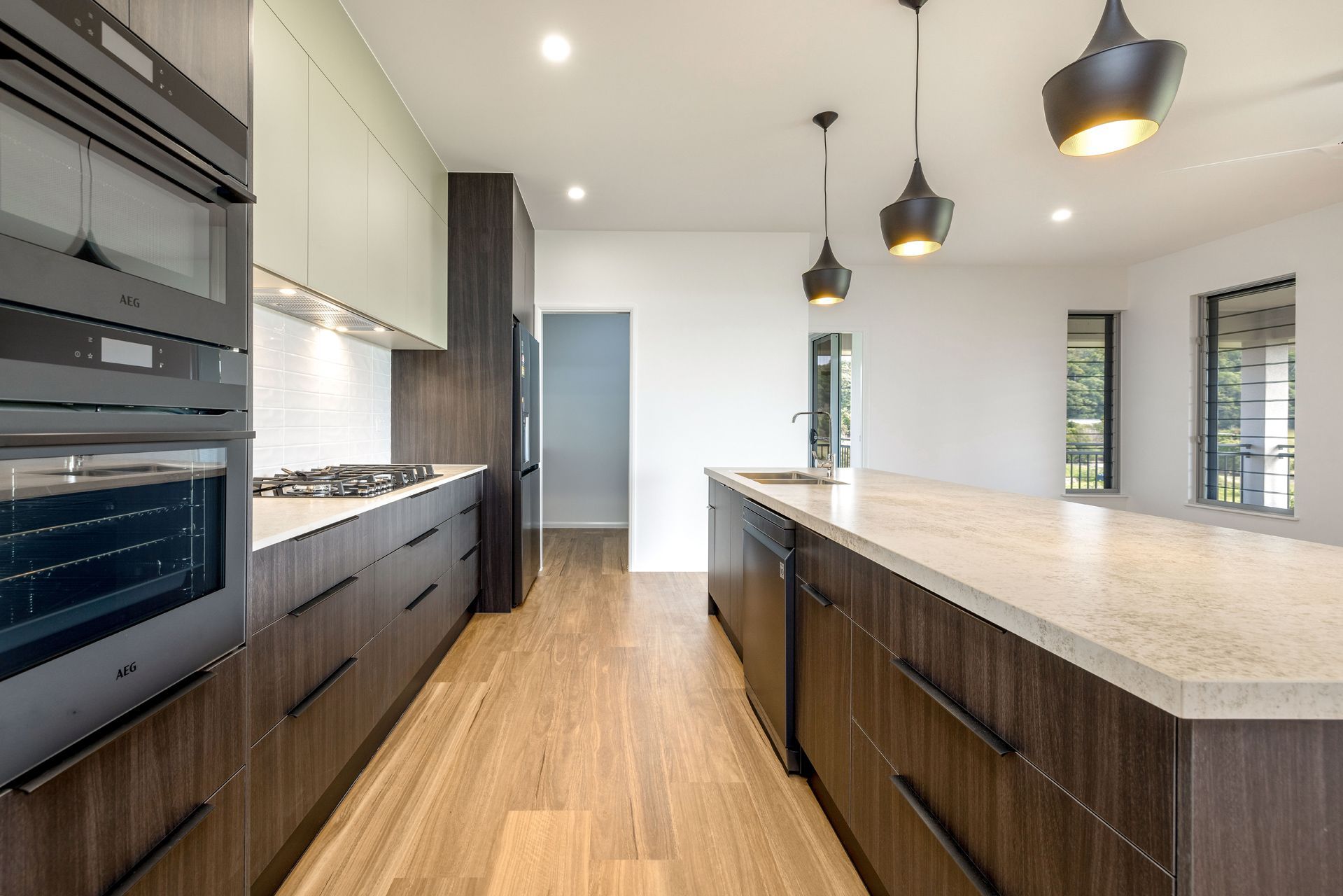Modern Kitchen With Dark Wood Cabinetry — Ashlee Jones Homes in Gordonvale, QLD