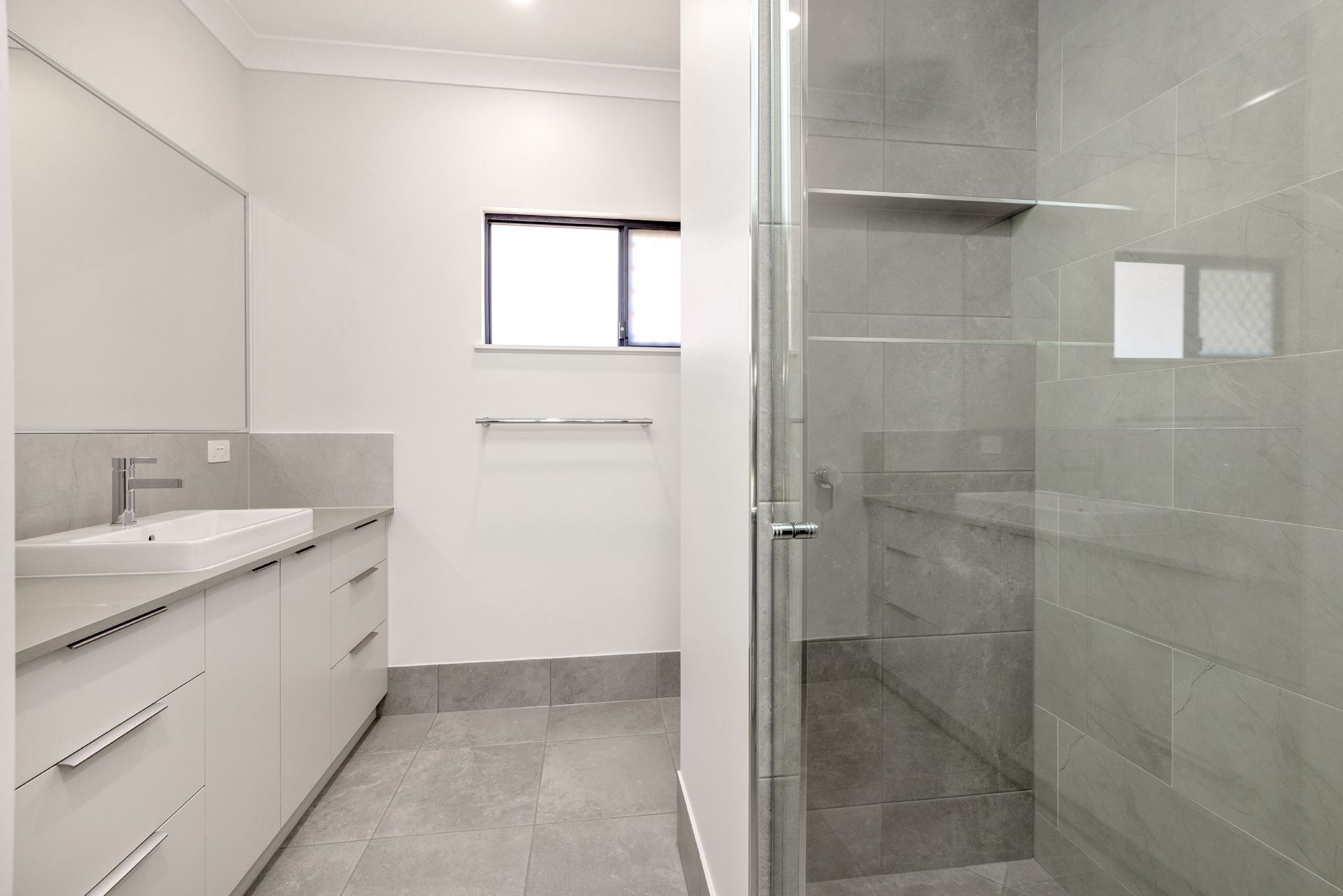 A Modern Bathroom Featuring a White Vanity With a Basin — Ashlee Jones Homes in Gordonvale, QLD