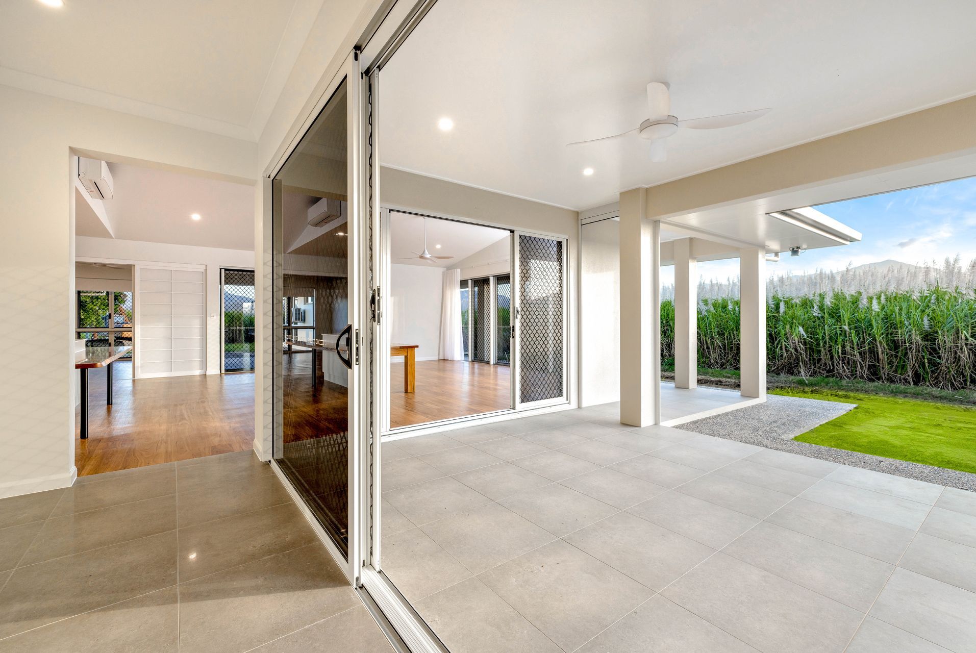 An Open-plan House Interior Transitioning to a Tiled Patio — Ashlee Jones Homes in Gordonvale, QLD