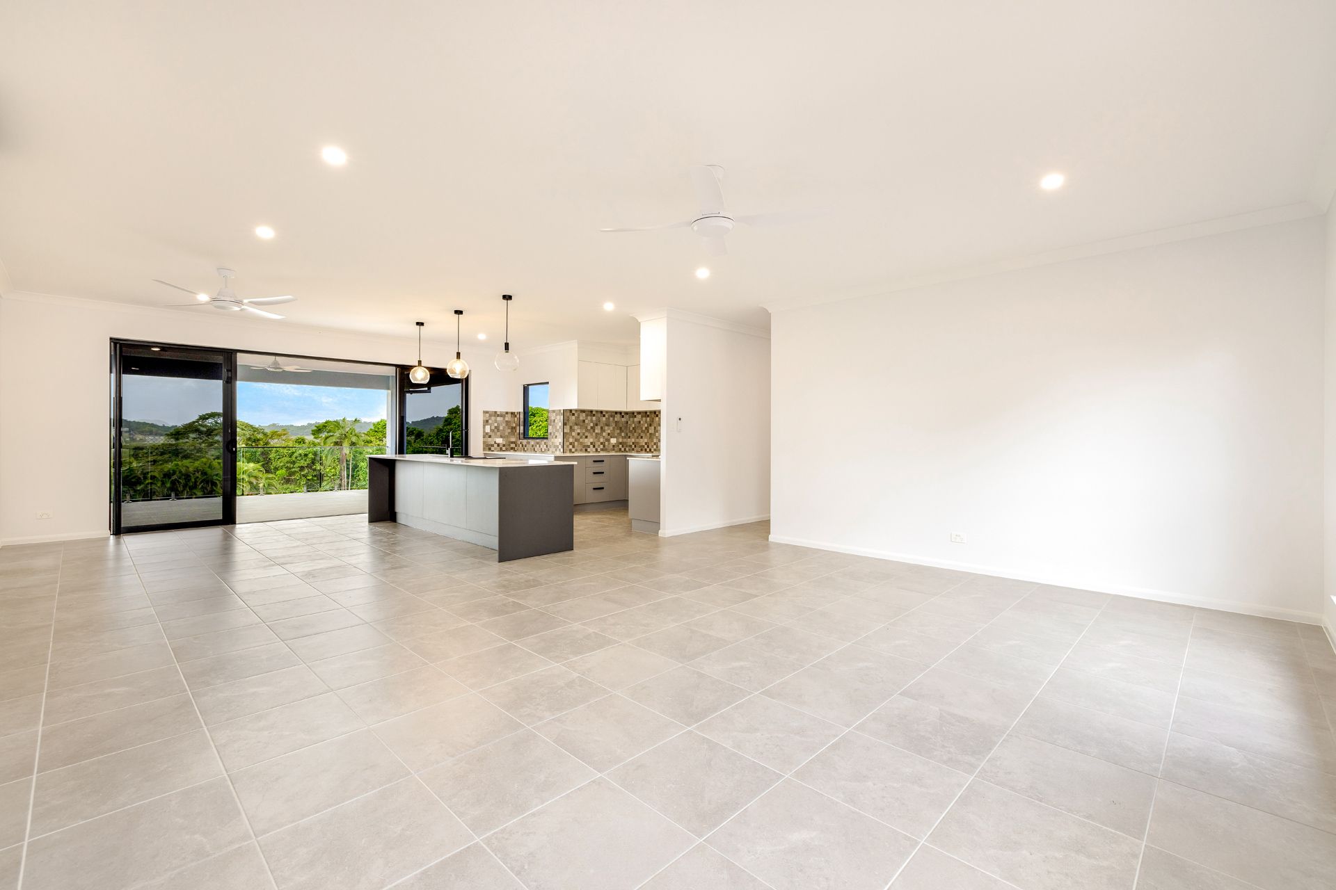 An Open-plan Living Room With Grey Tiled Flooring — Ashlee Jones Homes in Gordonvale, QLD