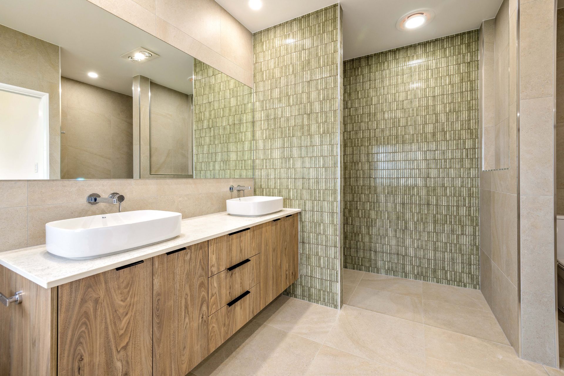 A Modern Bathroom Featuring a Double Vanity With White Vessel Sinks — Ashlee Jones Homes in Gordonvale, QLD