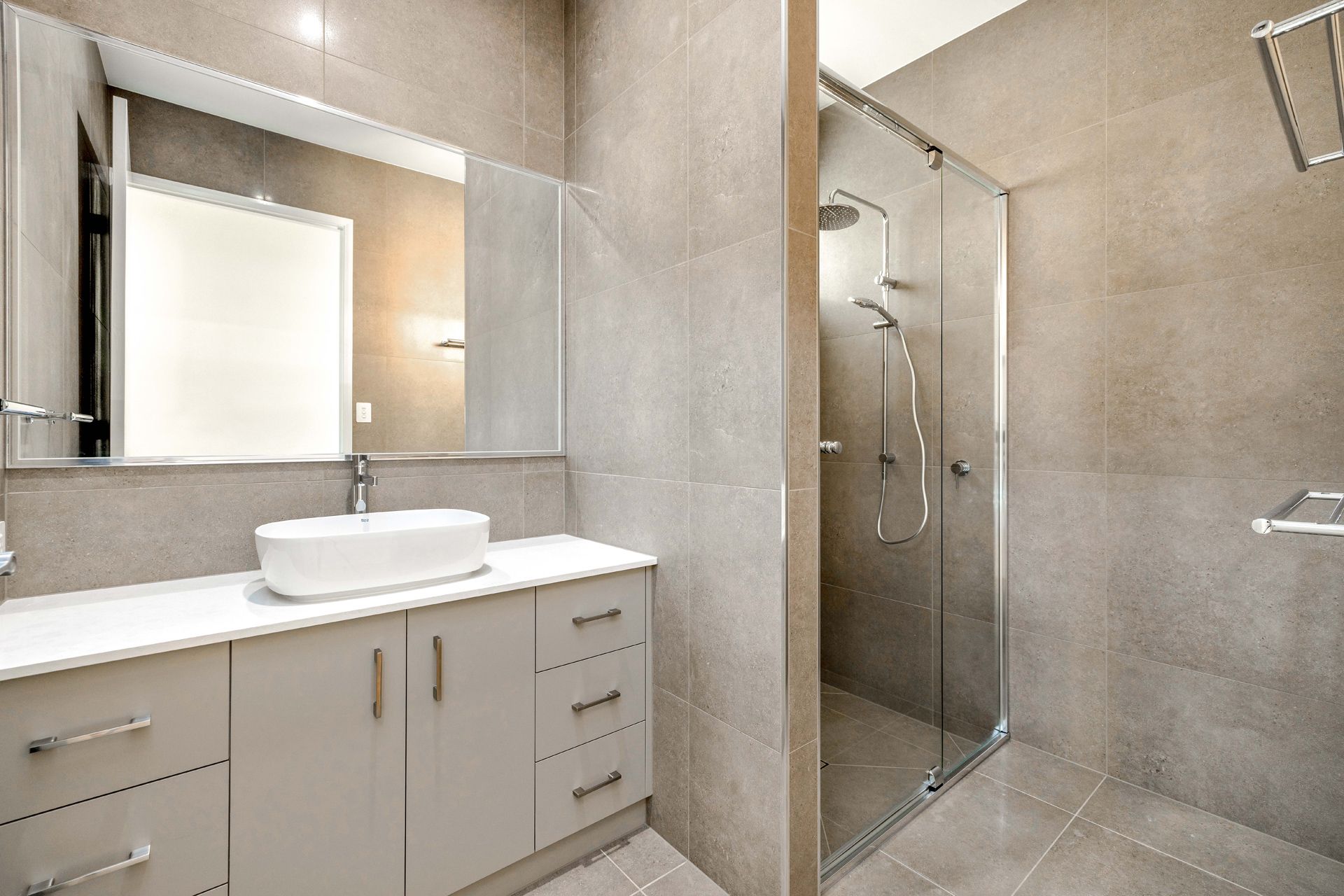 A Modern Bathroom With Light-toned Tiled Walls — Ashlee Jones Homes in Gordonvale, QLD
