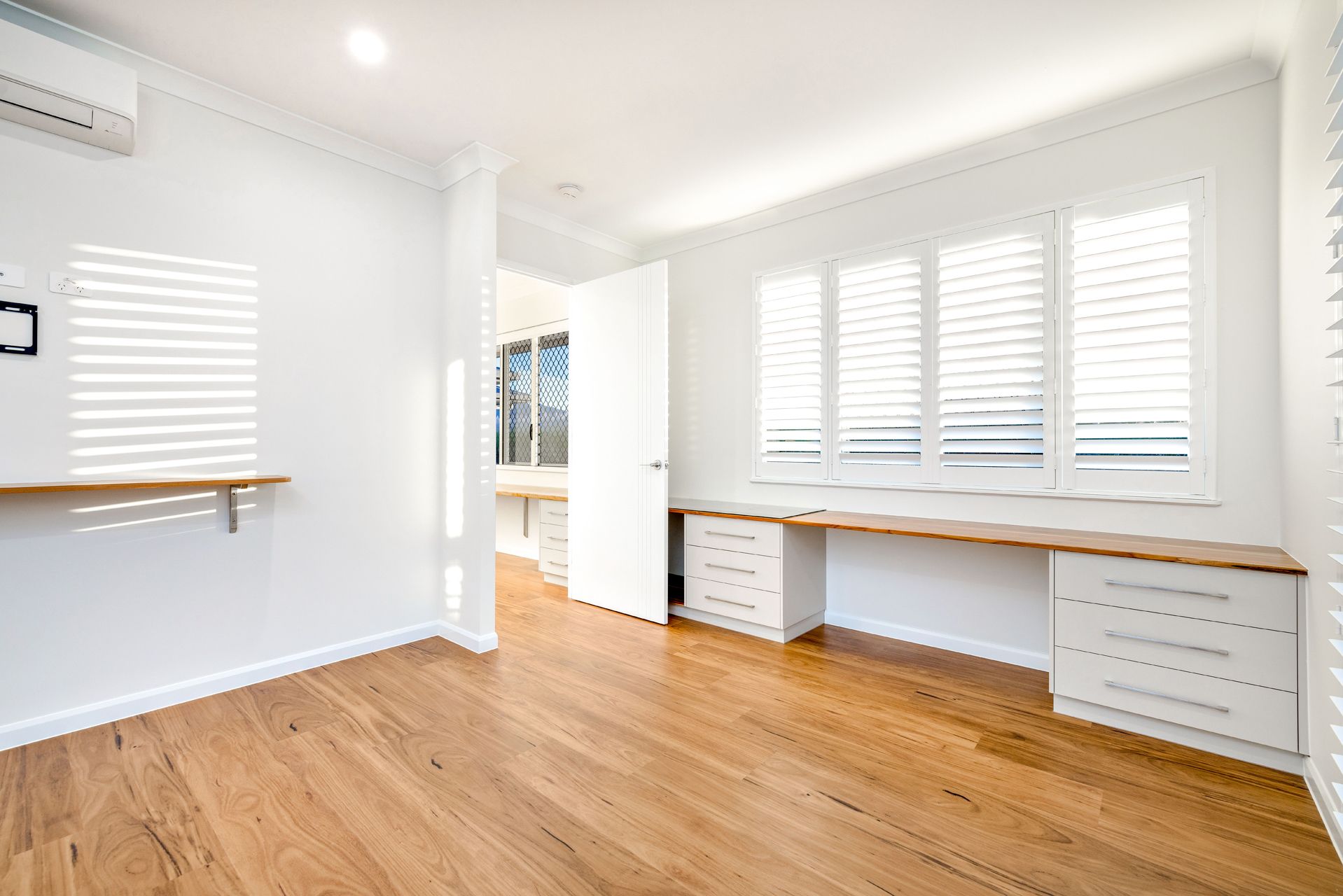 A Bright, Modern Room Featuring Light Wood Flooring — Ashlee Jones Homes in Gordonvale, QLD