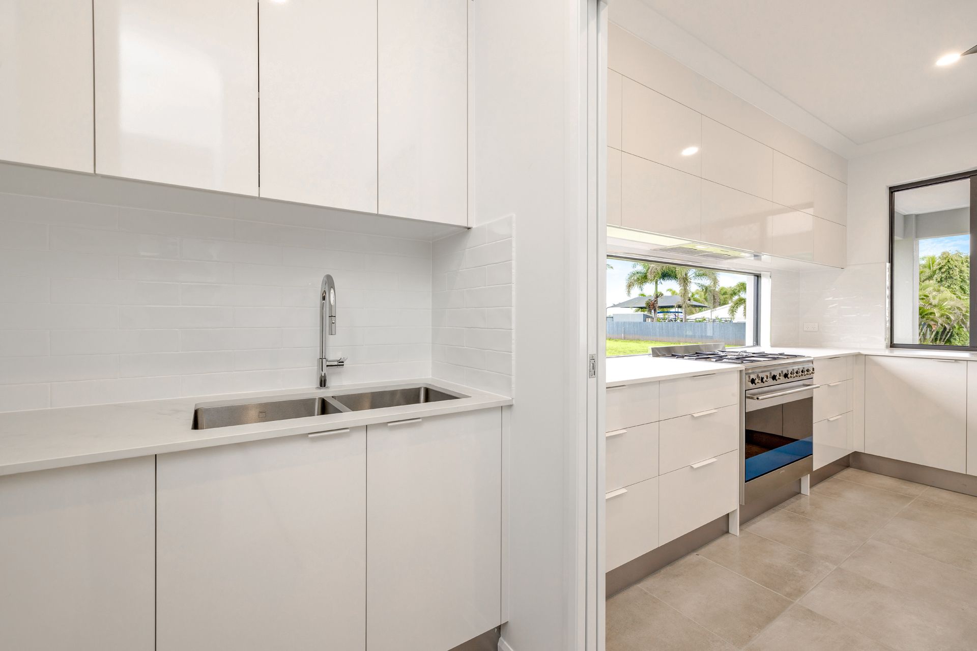 Modern, Minimalist Kitchen With Glossy White Cabinets — Ashlee Jones Homes in Gordonvale, QLD