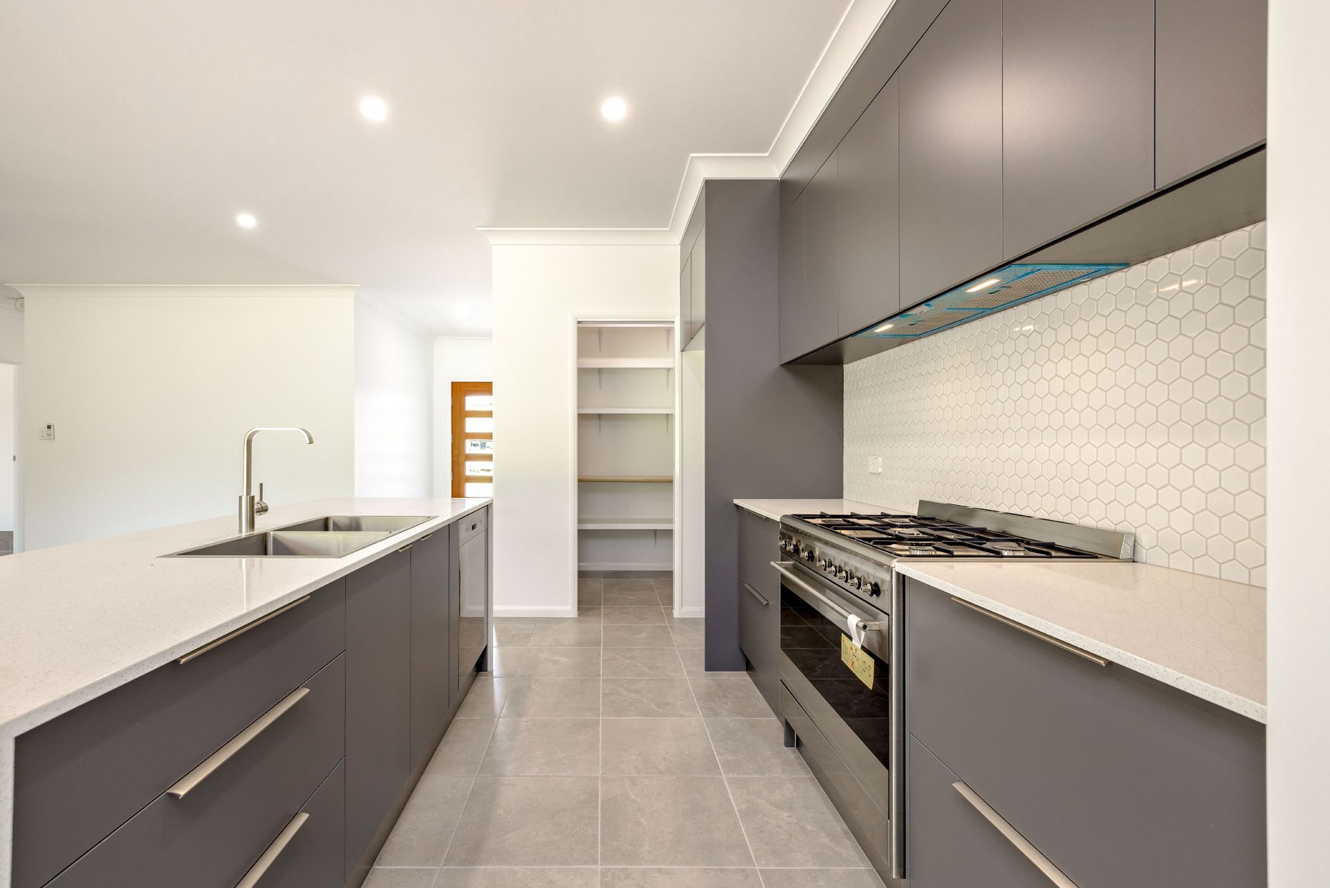 Modern Kitchen With Gray Cabinetry, White Stone Countertops — Ashlee Jones Homes in Gordonvale, QLD