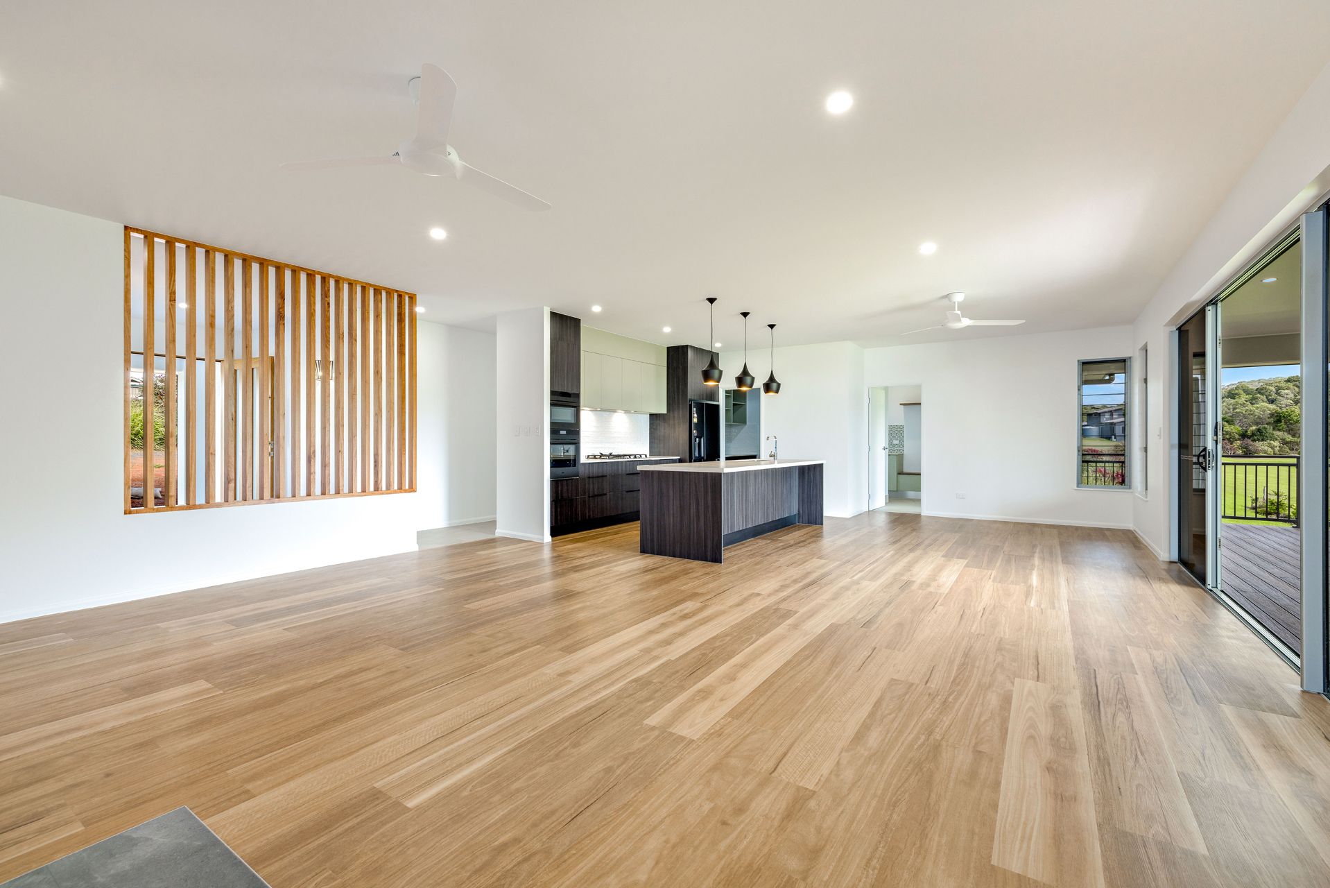 An Open-plan Living Room With Light Timber Floors — Ashlee Jones Homes in Gordonvale, QLD