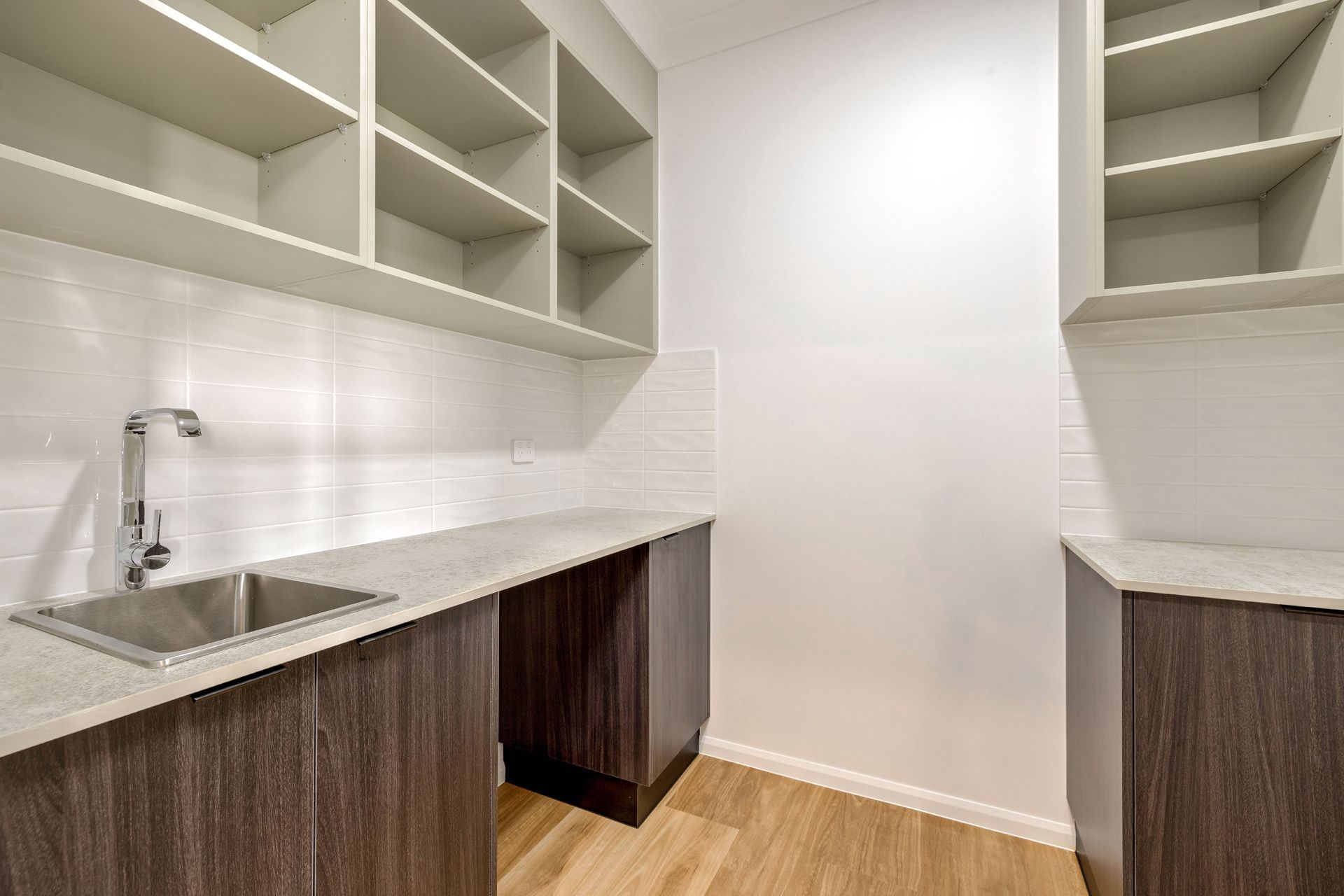 Modern Laundry Room With Dark Wood Cabinets, Light Stone Counters — Ashlee Jones Homes in Gordonvale, QLD
