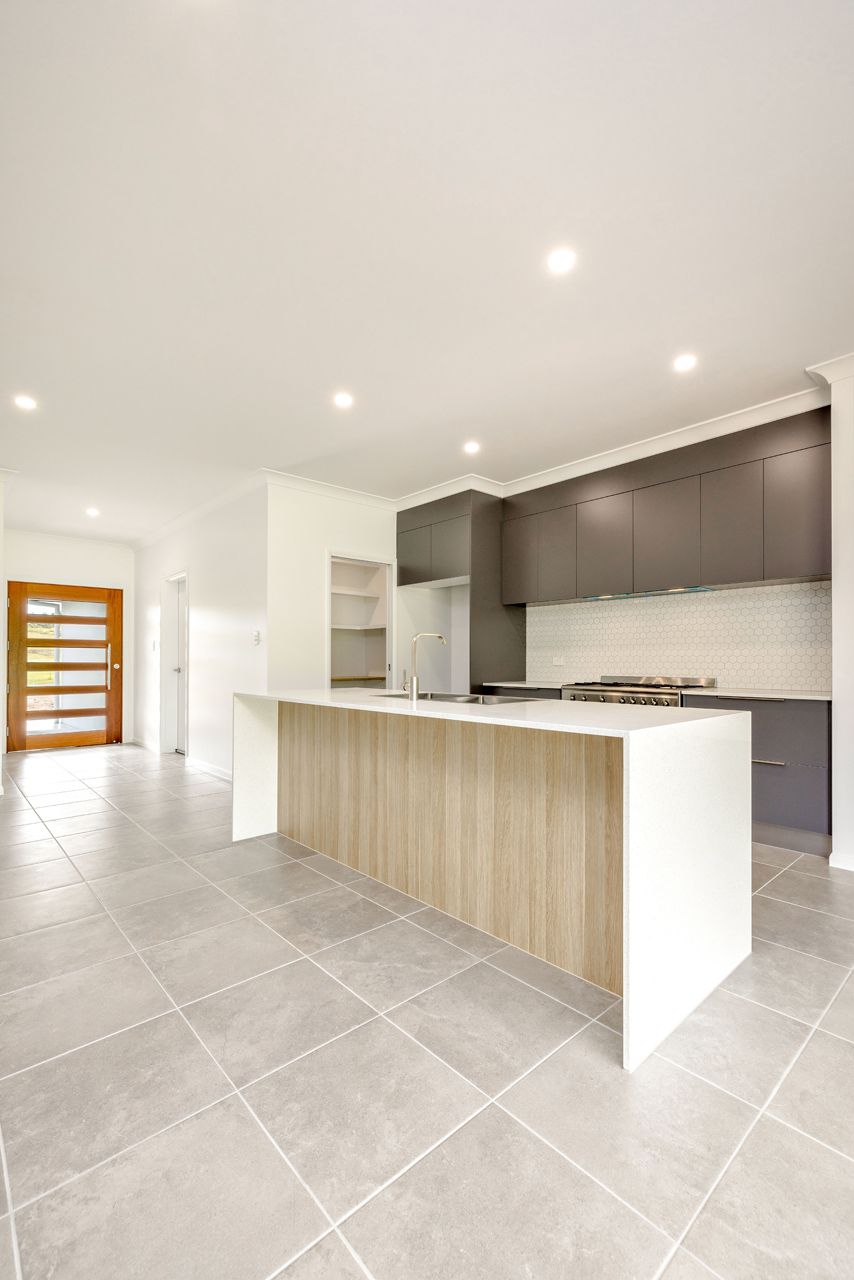 Modern Kitchen With a Light Wood Island, White Countertops — Ashlee Jones Homes in Gordonvale, QLD