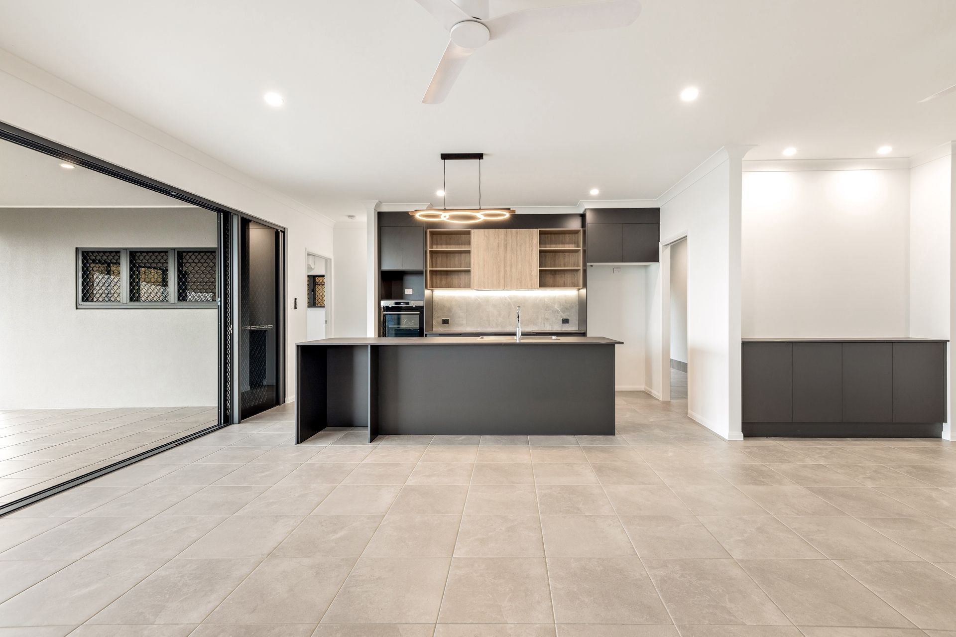 Modern Kitchen With Charcoal Cabinets, Wood Accents — Ashlee Jones Homes in Gordonvale, QLD