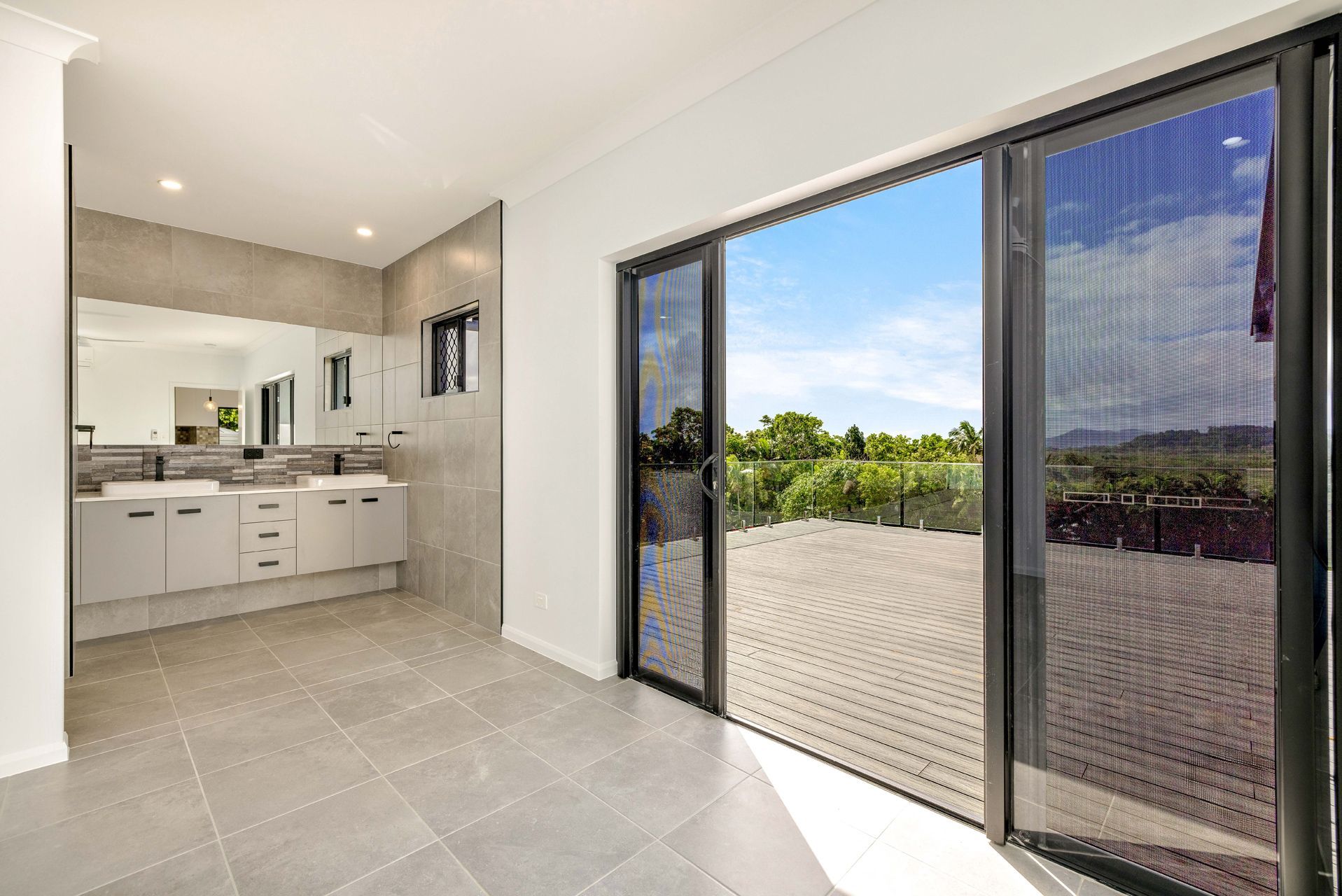 A Bright, Modern Bathroom With Gray Tile Floors — Ashlee Jones Homes in Gordonvale, QLD