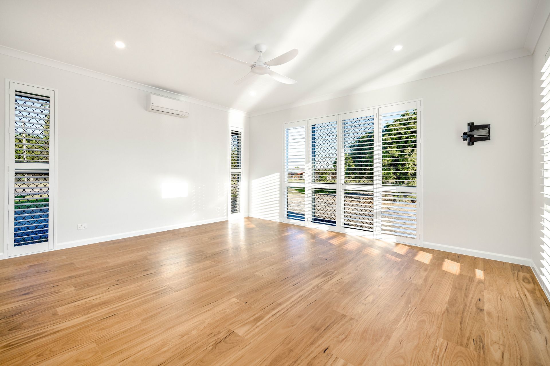 A Bright, Empty Living Space With Light Wood Floors — Ashlee Jones Homes in Gordonvale, QLD