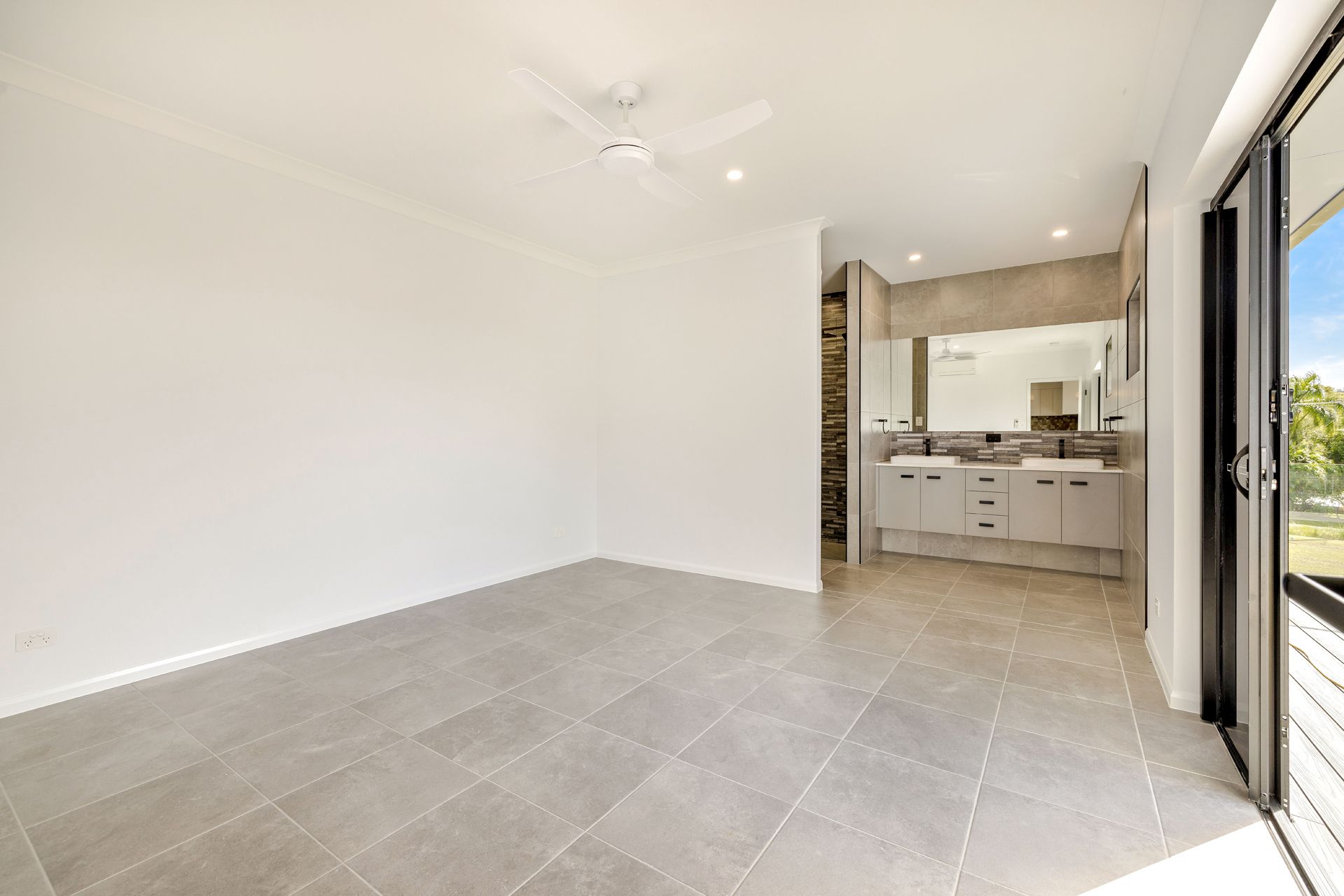 A Spacious Room With Light Gray Tile Flooring — Ashlee Jones Homes in Gordonvale, QLD