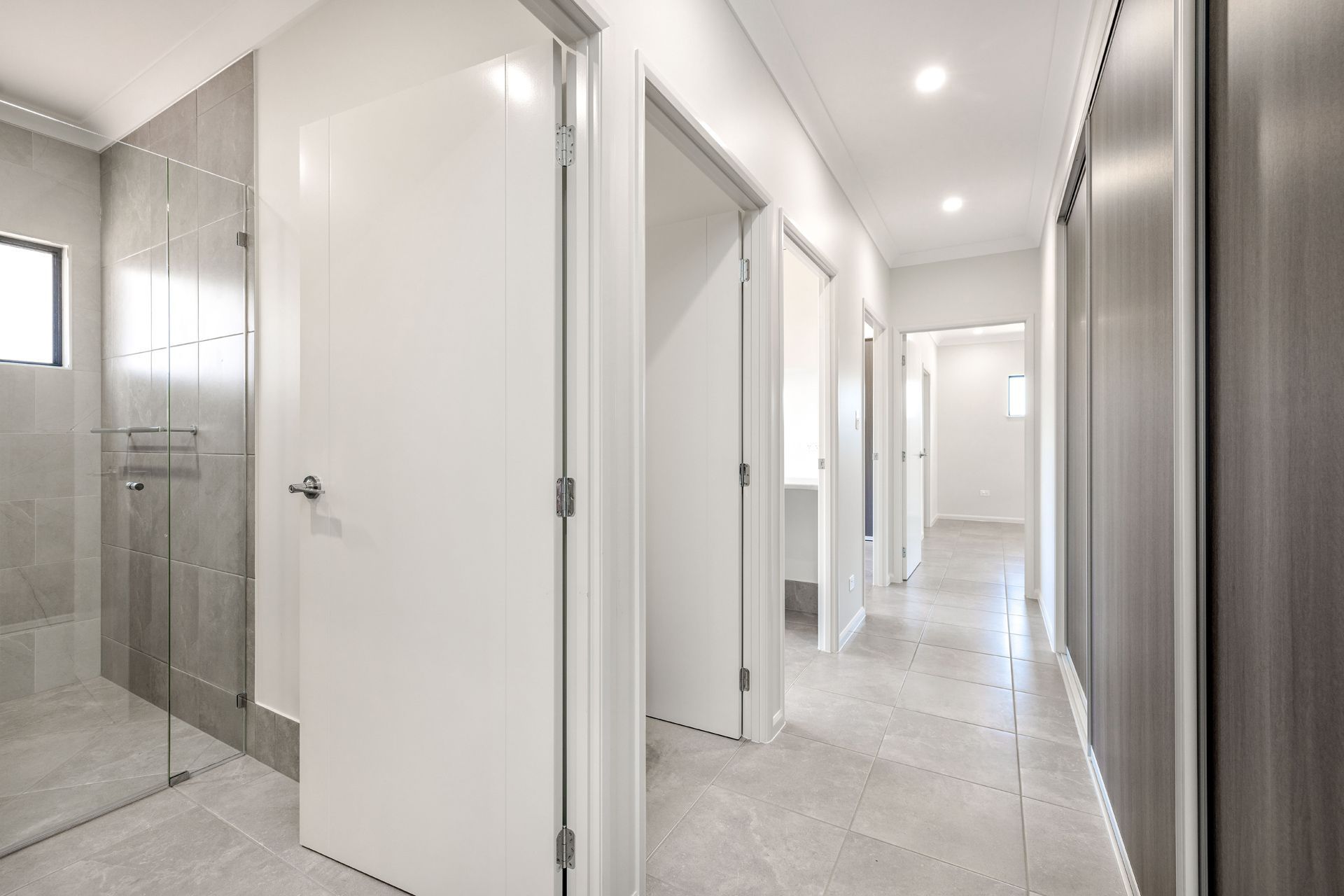 A Modern Hallway With Light Gray Floor Tiles, White Walls — Ashlee Jones Homes in Gordonvale, QLD