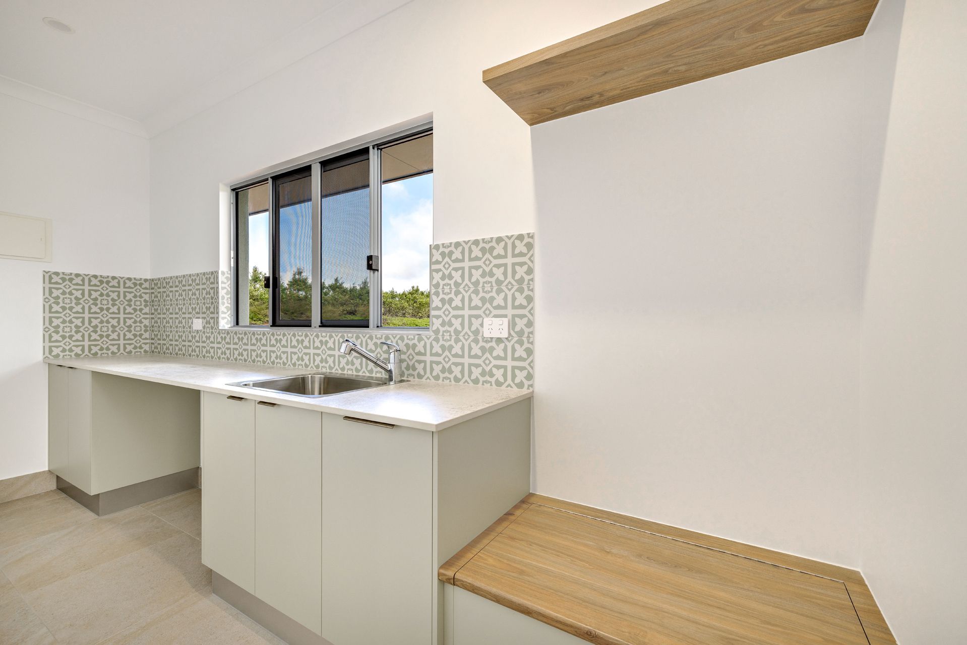Modern White Kitchen Featuring a Patterned Tile Backsplash — Ashlee Jones Homes in Gordonvale, QLD