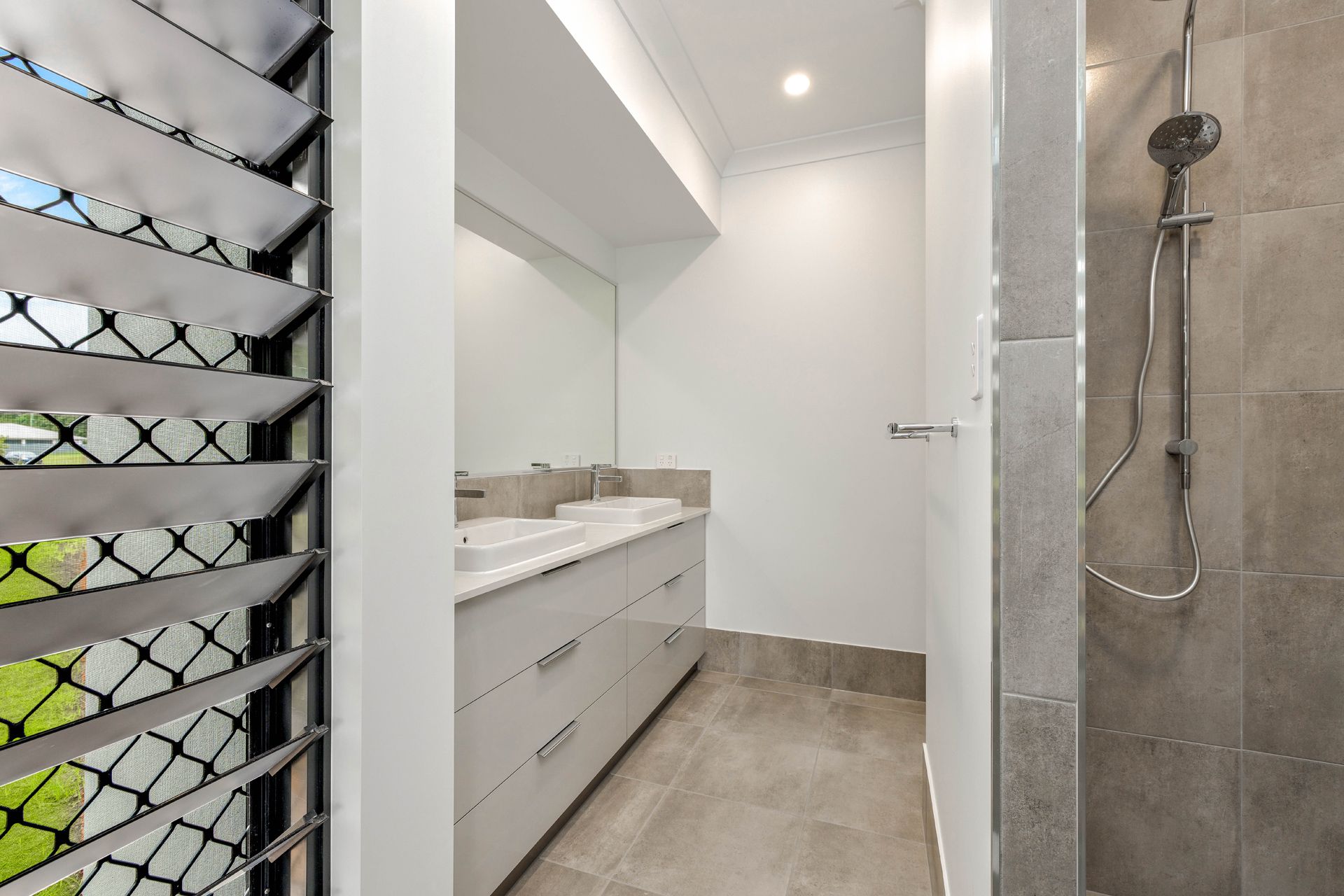 Modern Bathroom Featuring a Double Vanity With White Cabinets — Ashlee Jones Homes in Gordonvale, QLD