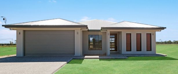 A House With A Garage And A Lawn In Front Of It — Ashlee Jones Homes in Gordonvale, QLD