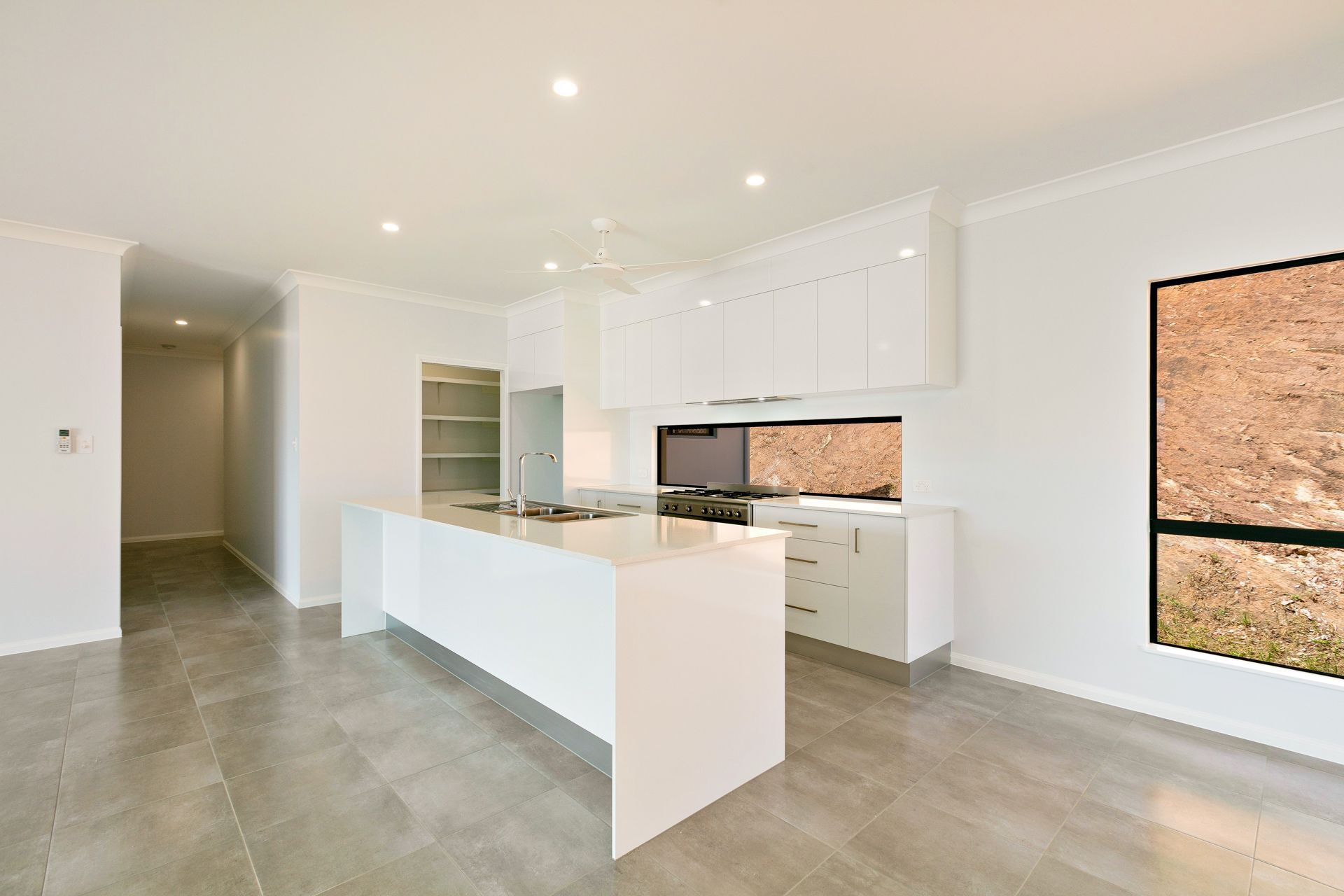 A Modern, Minimalist Kitchen With White Cabinetry — Ashlee Jones Homes in Gordonvale, QLD