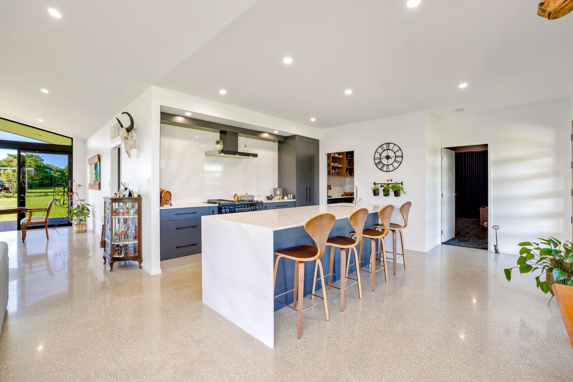 Modern Kitchen With a White Quartz Island, Four Wooden Stools — Ashlee Jones Homes in Gordonvale, QLD