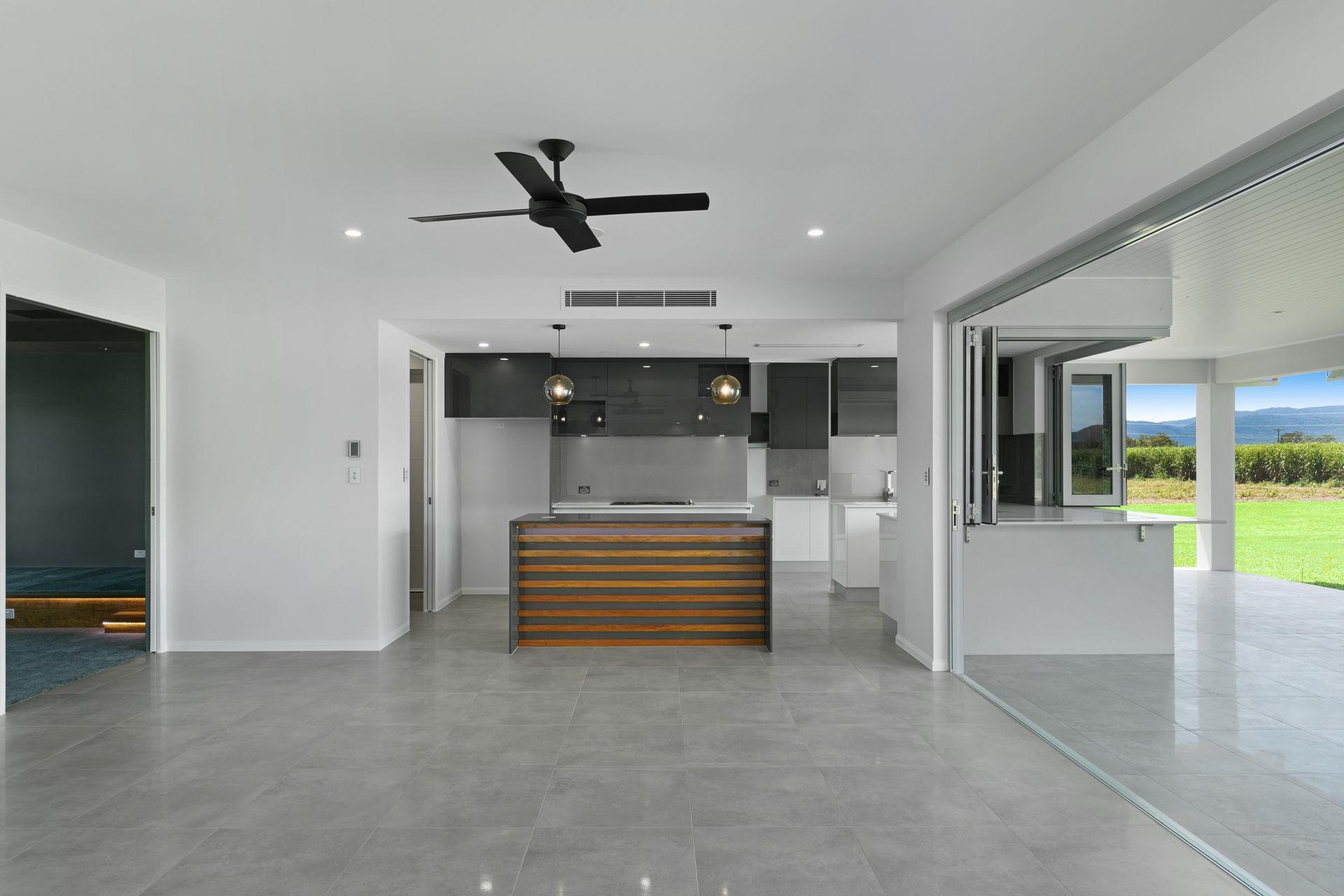 Modern Open-plan Kitchen and Living Space With Gray Tiled Floors — Ashlee Jones Homes in Gordonvale, QLD