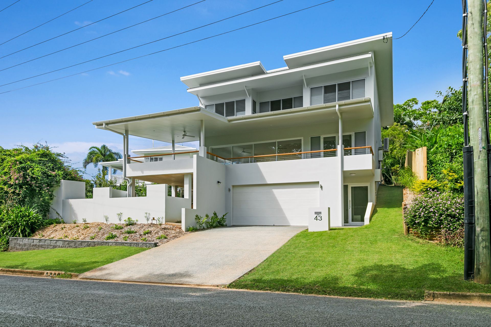 A Modern, White Multi-story Home With a Large Covered Balcony — Ashlee Jones Homes in Gordonvale, QLD
