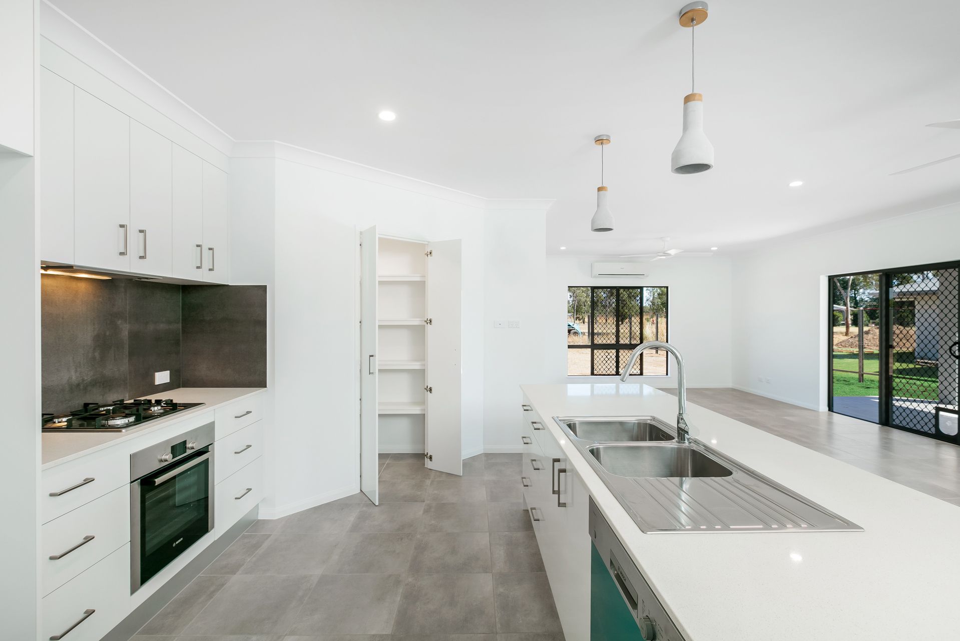 A Modern, Minimalist Kitchen With White Cabinets — Ashlee Jones Homes in Gordonvale, QLD