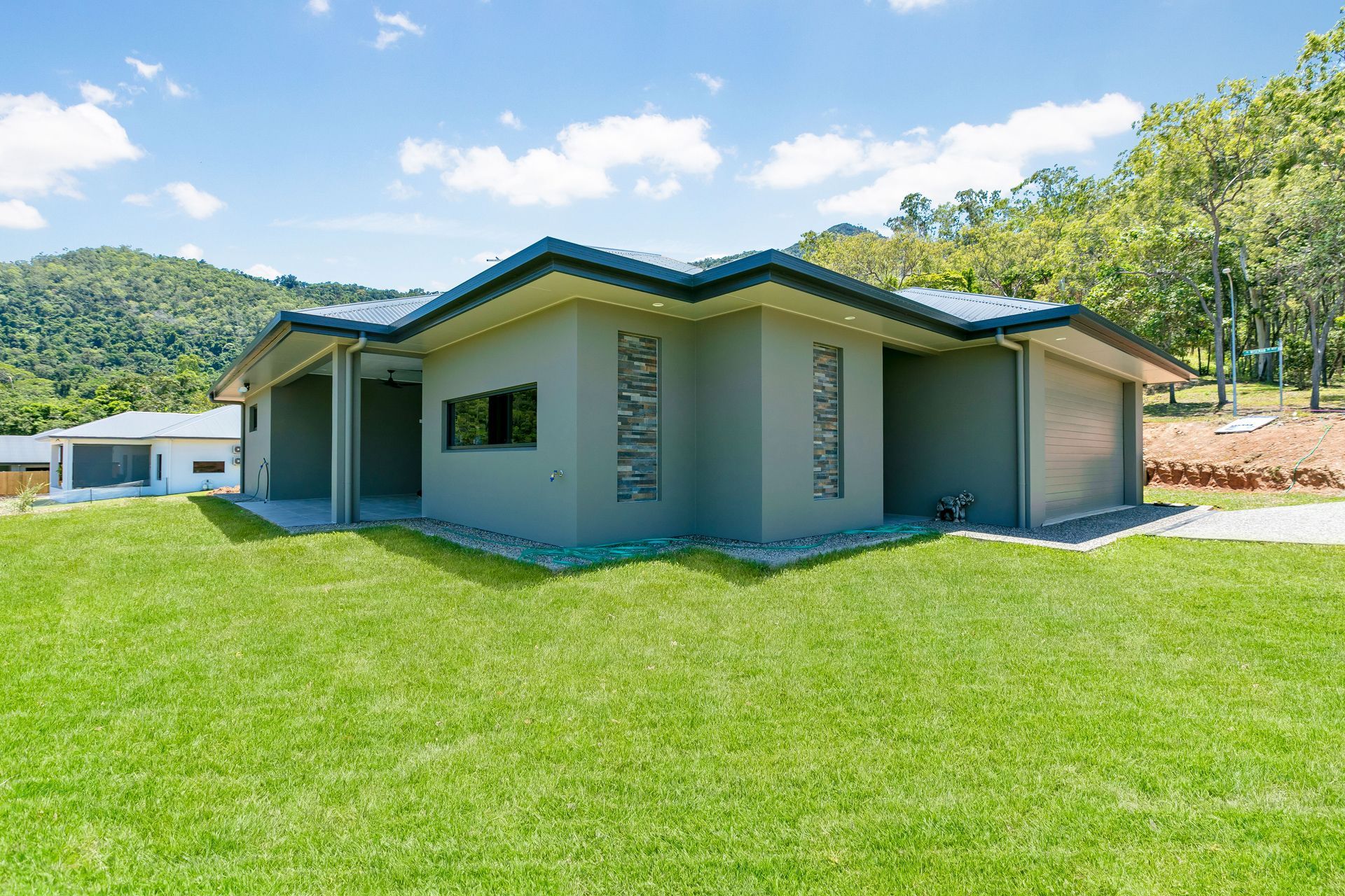 A Modern, Grey, Single-story House With a Hip Roof — Ashlee Jones Homes in Gordonvale, QLD
