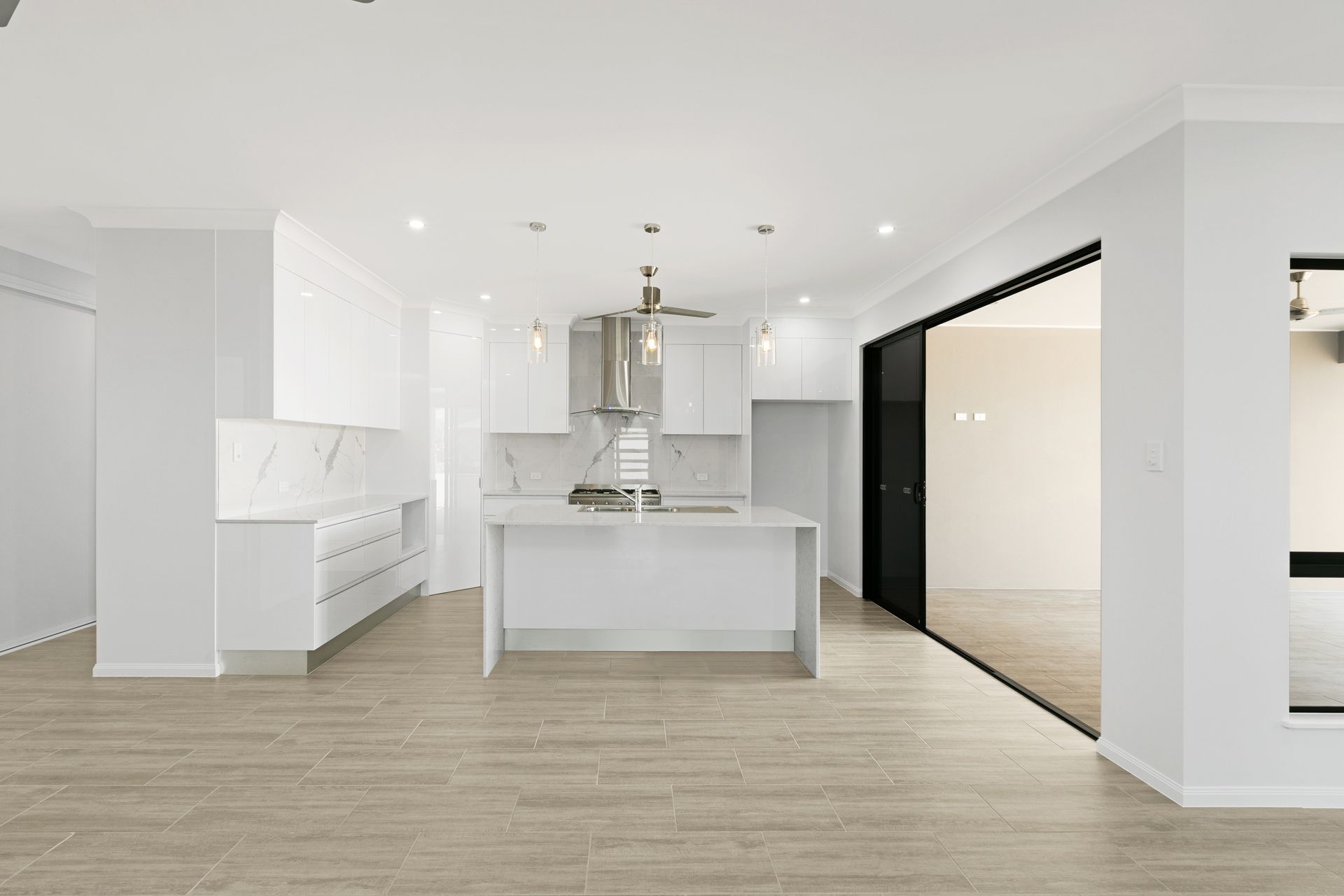 A Modern, Minimalist Kitchen Featuring White Cabinets — Ashlee Jones Homes in Gordonvale, QLD