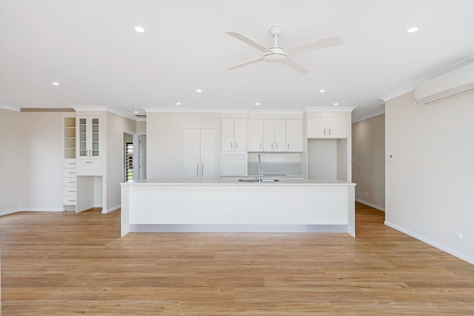 A Bright, Modern Open-plan Kitchen and Living Space With White Cabinetry — Ashlee Jones Homes in Gordonvale, QLD