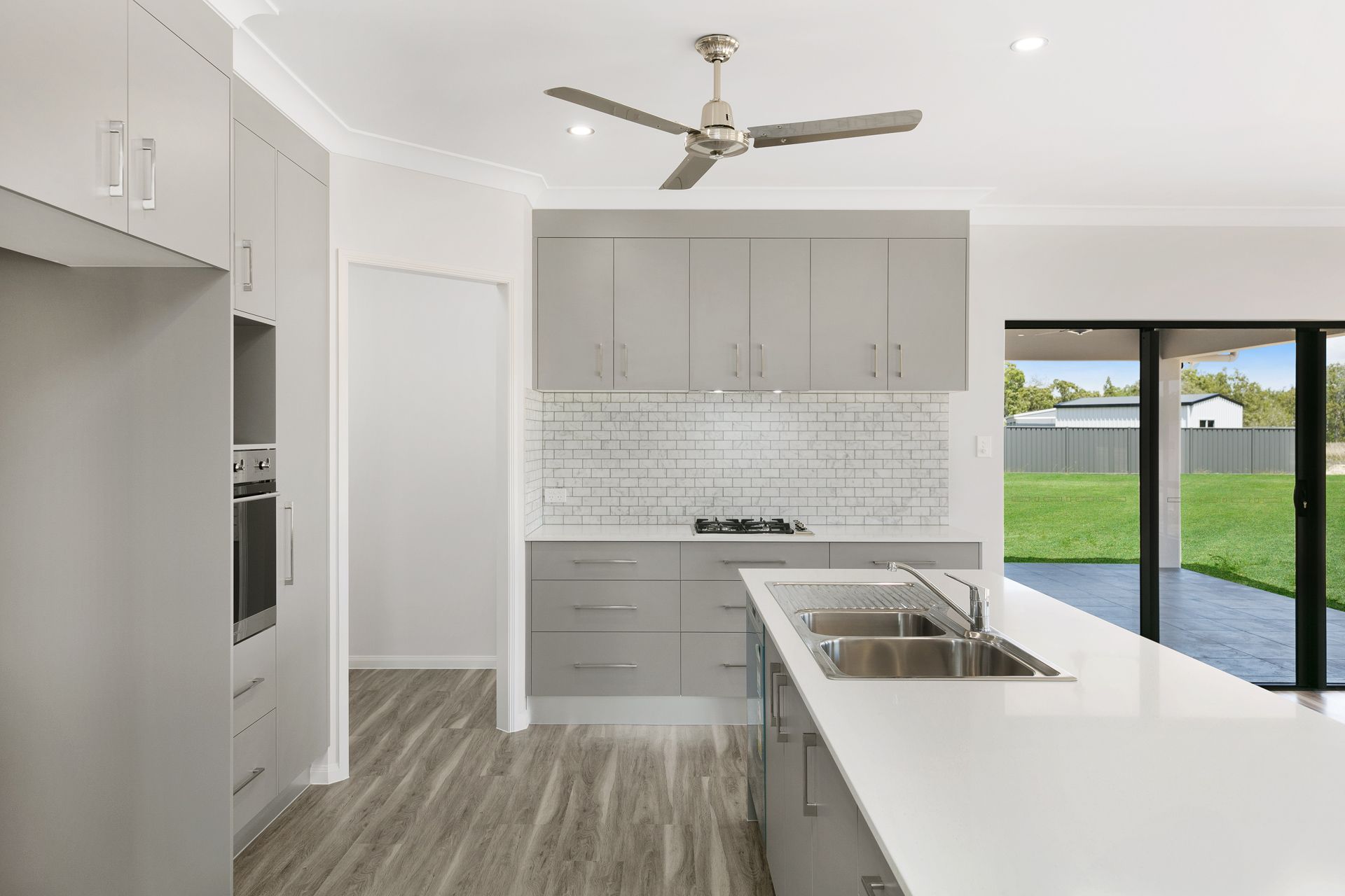 A Bright, Modern Kitchen With Grey Cabinetry — Ashlee Jones Homes in Gordonvale, QLD