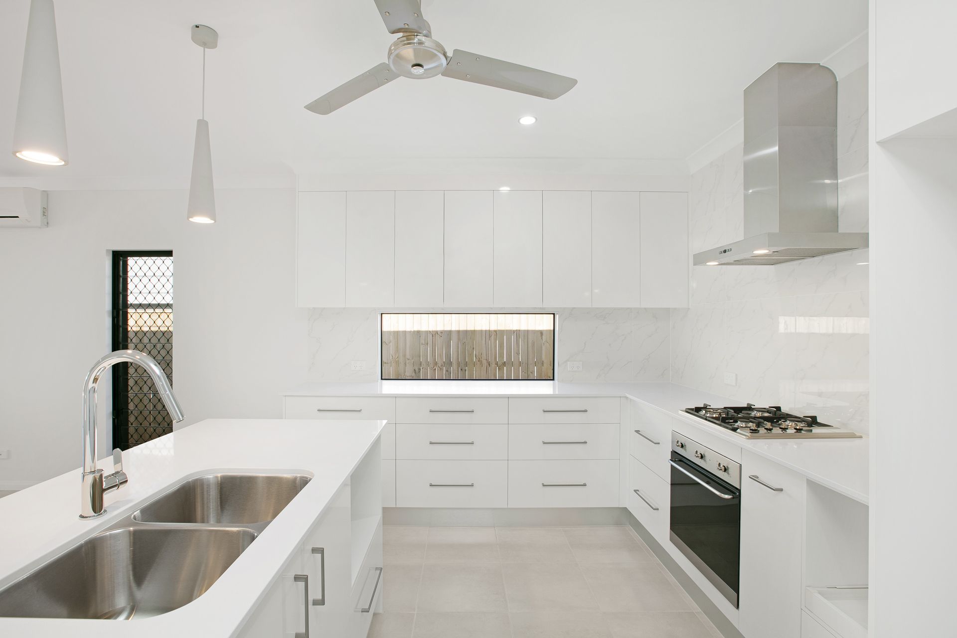 A Bright, Modern Kitchen With White Cabinets — Ashlee Jones Homes in Gordonvale, QLD