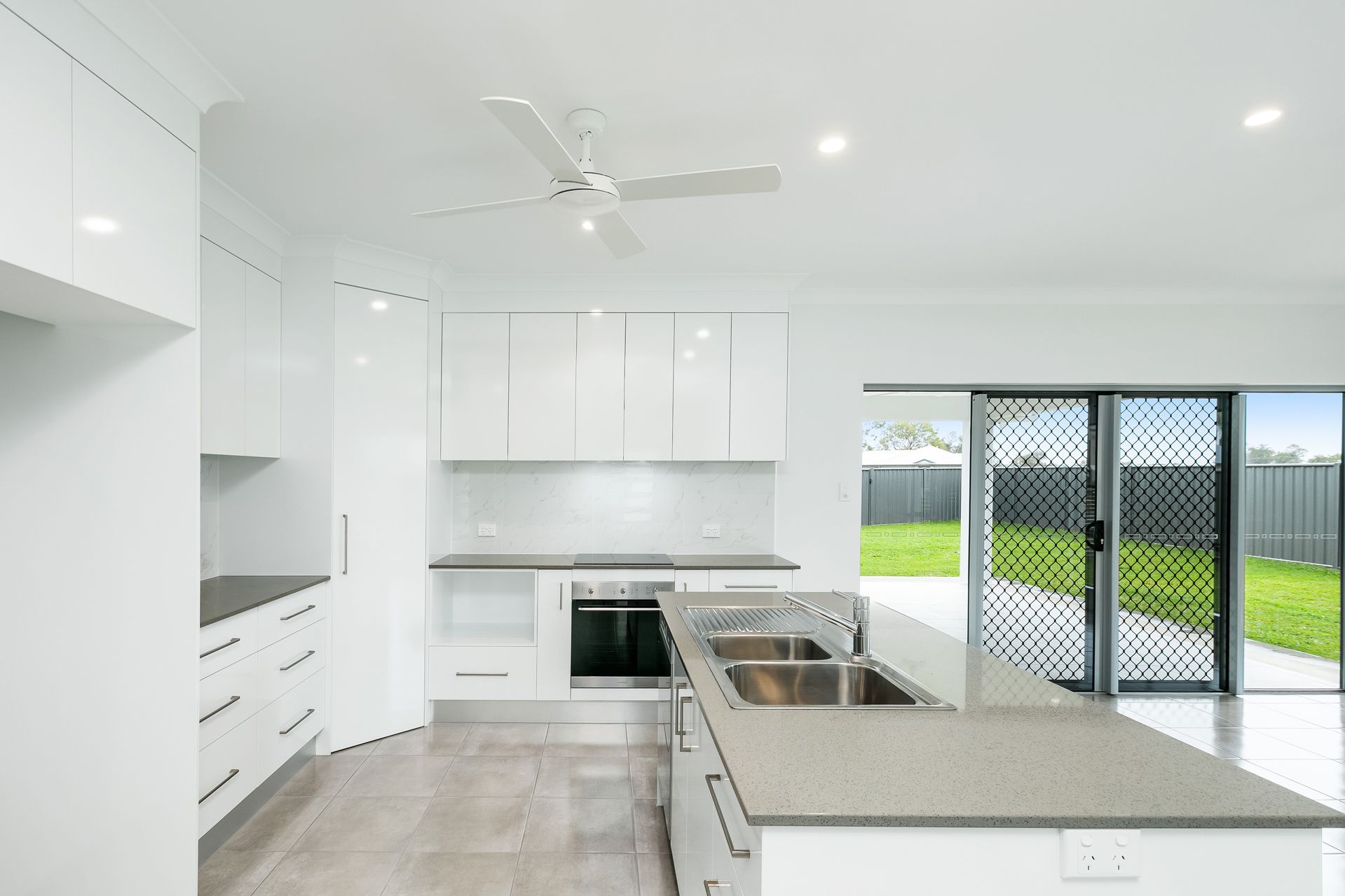 A Bright, Modern Kitchen Featuring White Cabinetry — Ashlee Jones Homes in Gordonvale, QLD