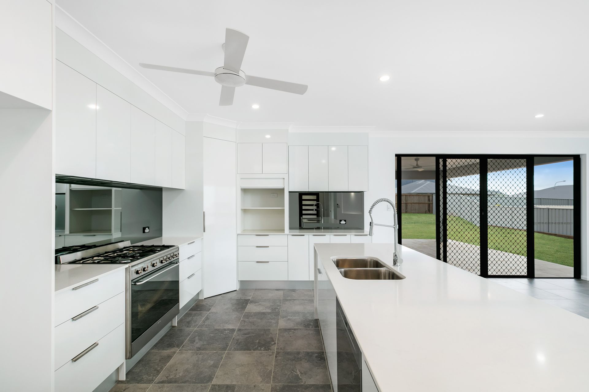 Modern White Kitchen With Stainless Steel Appliances — Ashlee Jones Homes in Gordonvale, QLD