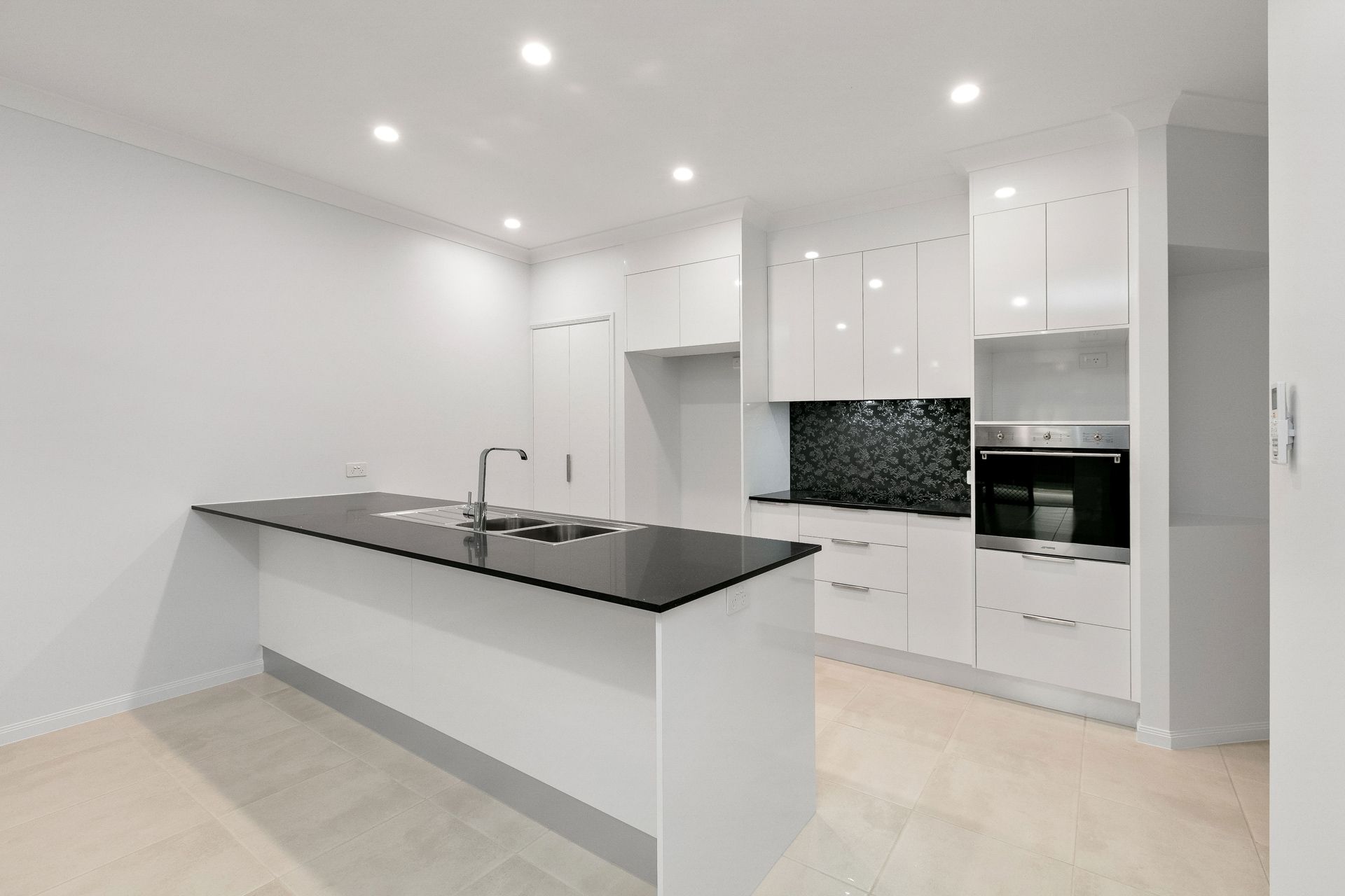 Modern Kitchen With White Cabinets, a Black Island Countertop — Ashlee Jones Homes in Gordonvale, QLD