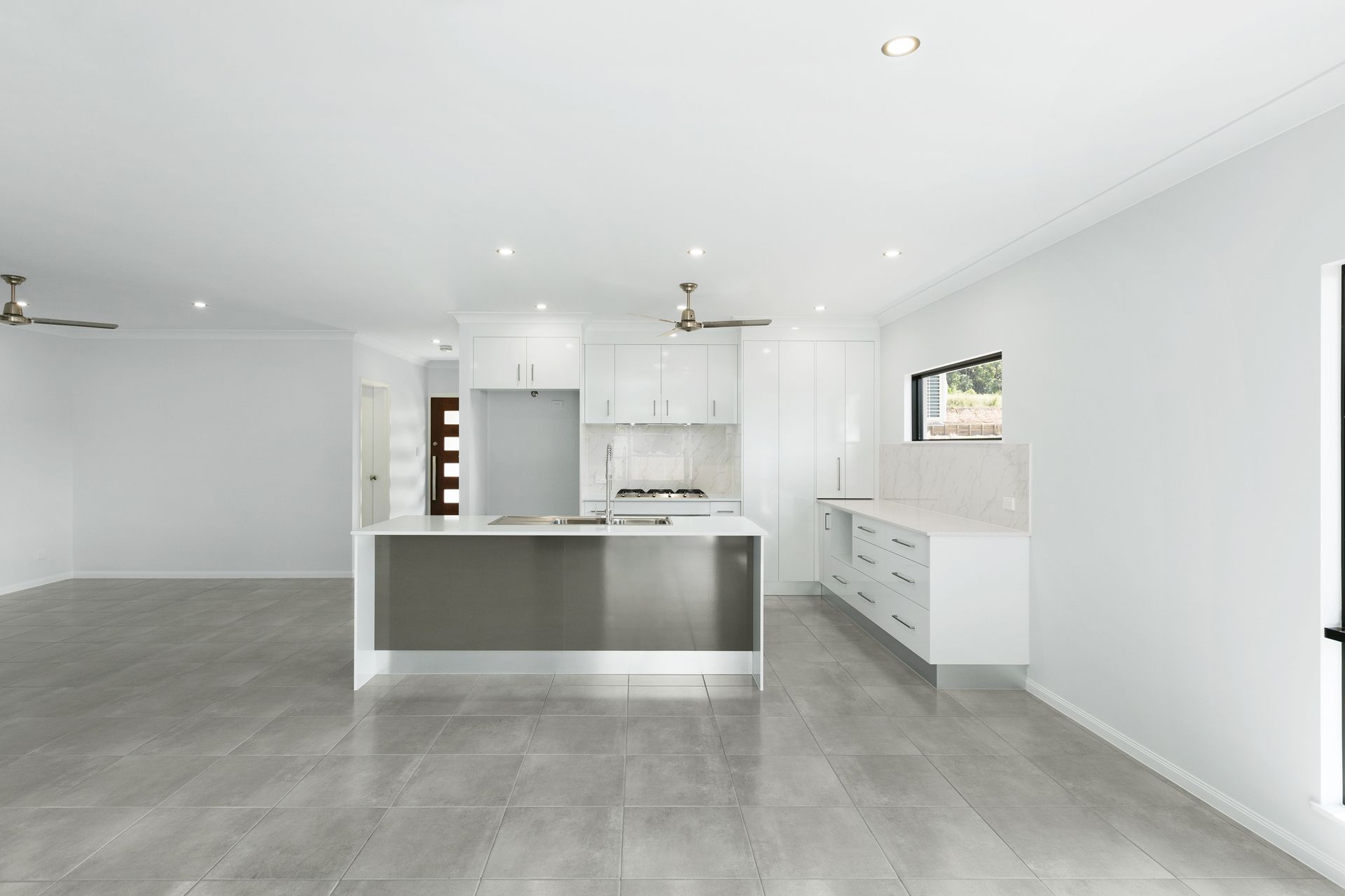 A Modern Open-plan Kitchen With White Cabinetry — Ashlee Jones Homes in Gordonvale, QLD