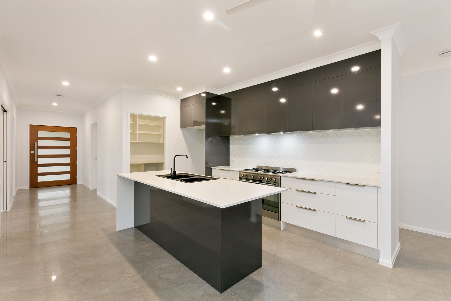 A Modern Kitchen With a Grey and White Island — Ashlee Jones Homes in Gordonvale, QLD