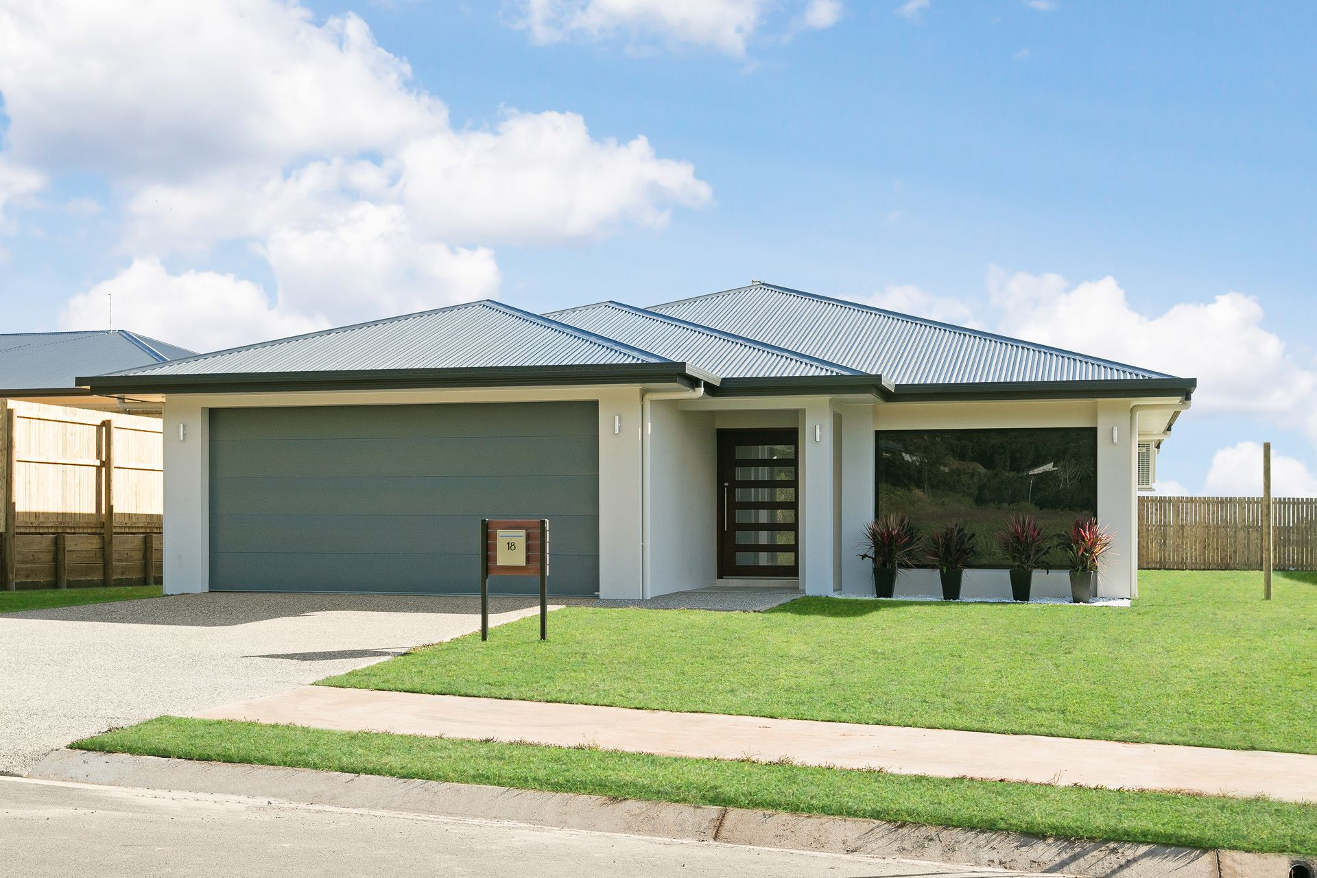 A Single-story Suburban House With a Gray Garage Door — Ashlee Jones Homes in Gordonvale, QLD