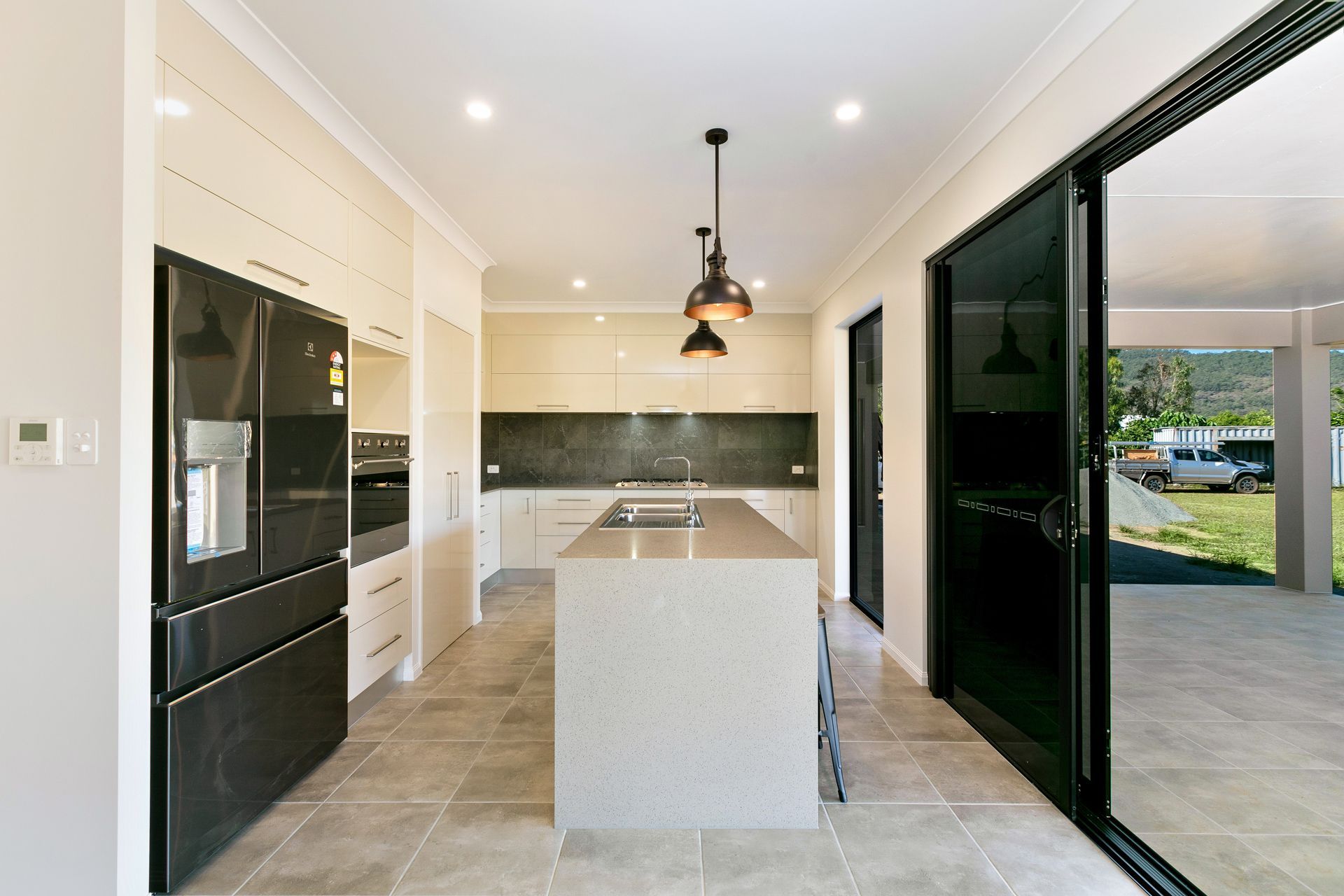 Modern Kitchen With Cream Cabinets, a Large Island — Ashlee Jones Homes in Gordonvale, QLD
