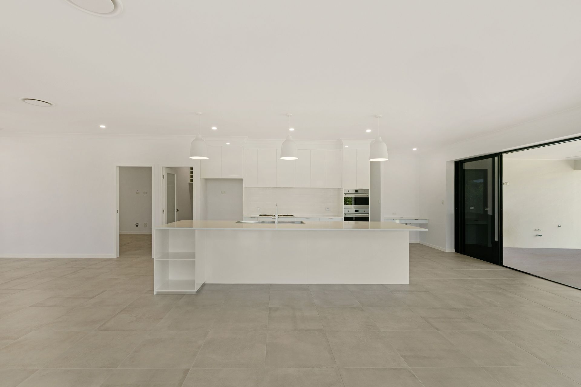 A Modern, Minimalist White Kitchen Island and Cabinets — Ashlee Jones Homes in Gordonvale, QLD