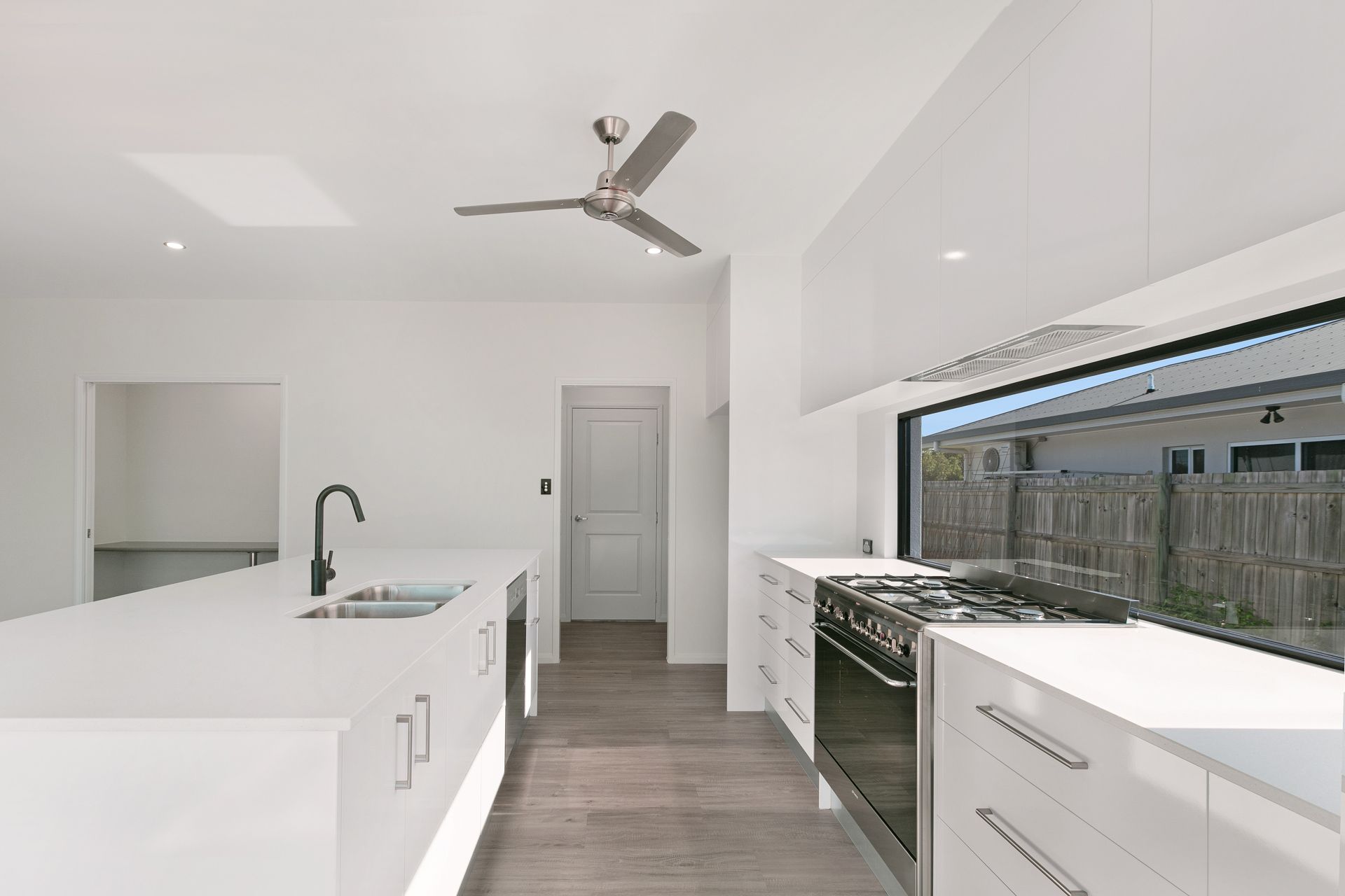 A Bright, Modern Kitchen Featuring White Cabinets — Ashlee Jones Homes in Gordonvale, QLD