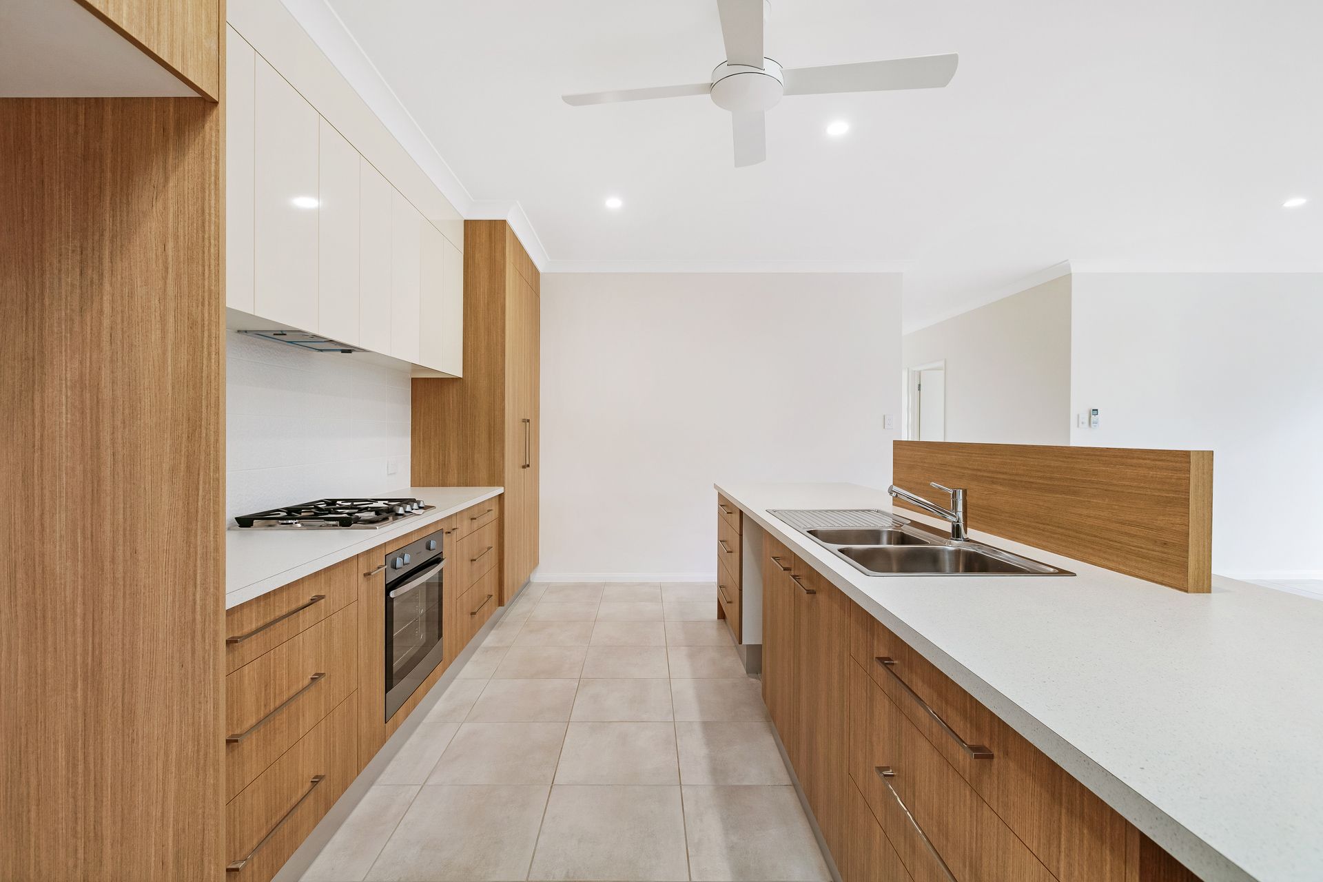 Modern Kitchen Featuring White Cabinets, Wood-grain Lower Cabinets — Ashlee Jones Homes in Gordonvale, QLD