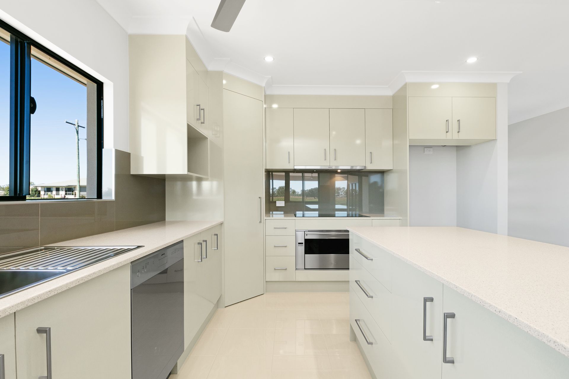 A Modern Kitchen Featuring Off-white Cabinets — Ashlee Jones Homes in Gordonvale, QLD