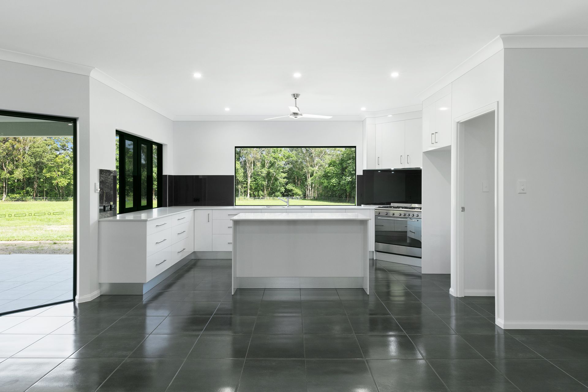 Modern Kitchen With White Cabinetry, Black Tile Floor — Ashlee Jones Homes in Gordonvale, QLD