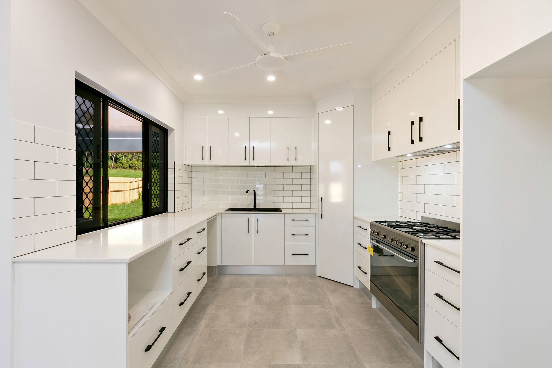 A Modern Kitchen With White Cabinetry, a White Subway-tile Backsplash — Ashlee Jones Homes in Gordonvale, QLD