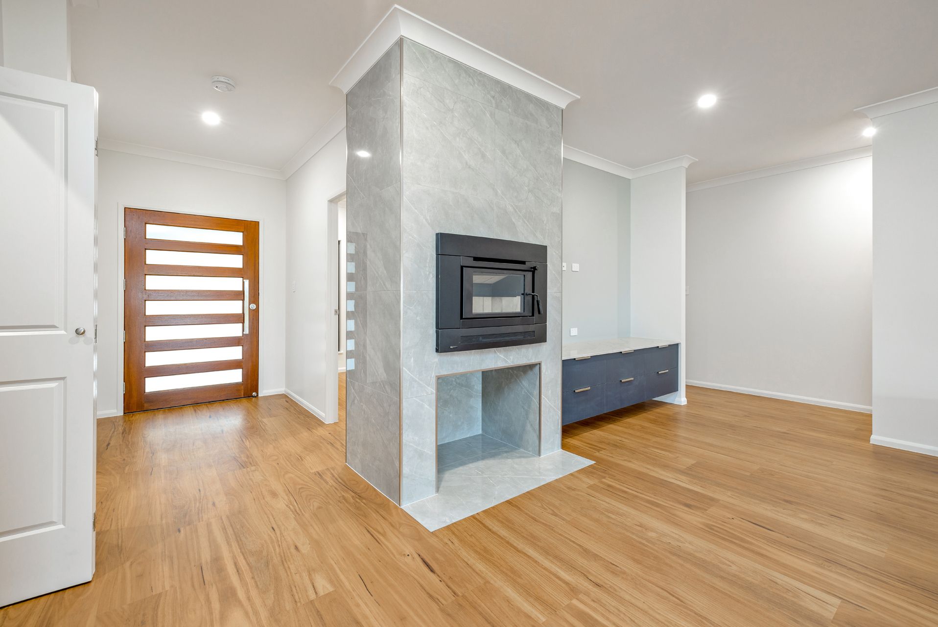 A Modern Living Room With a Concrete-finish Fireplace Partition — Ashlee Jones Homes in Gordonvale, QLD