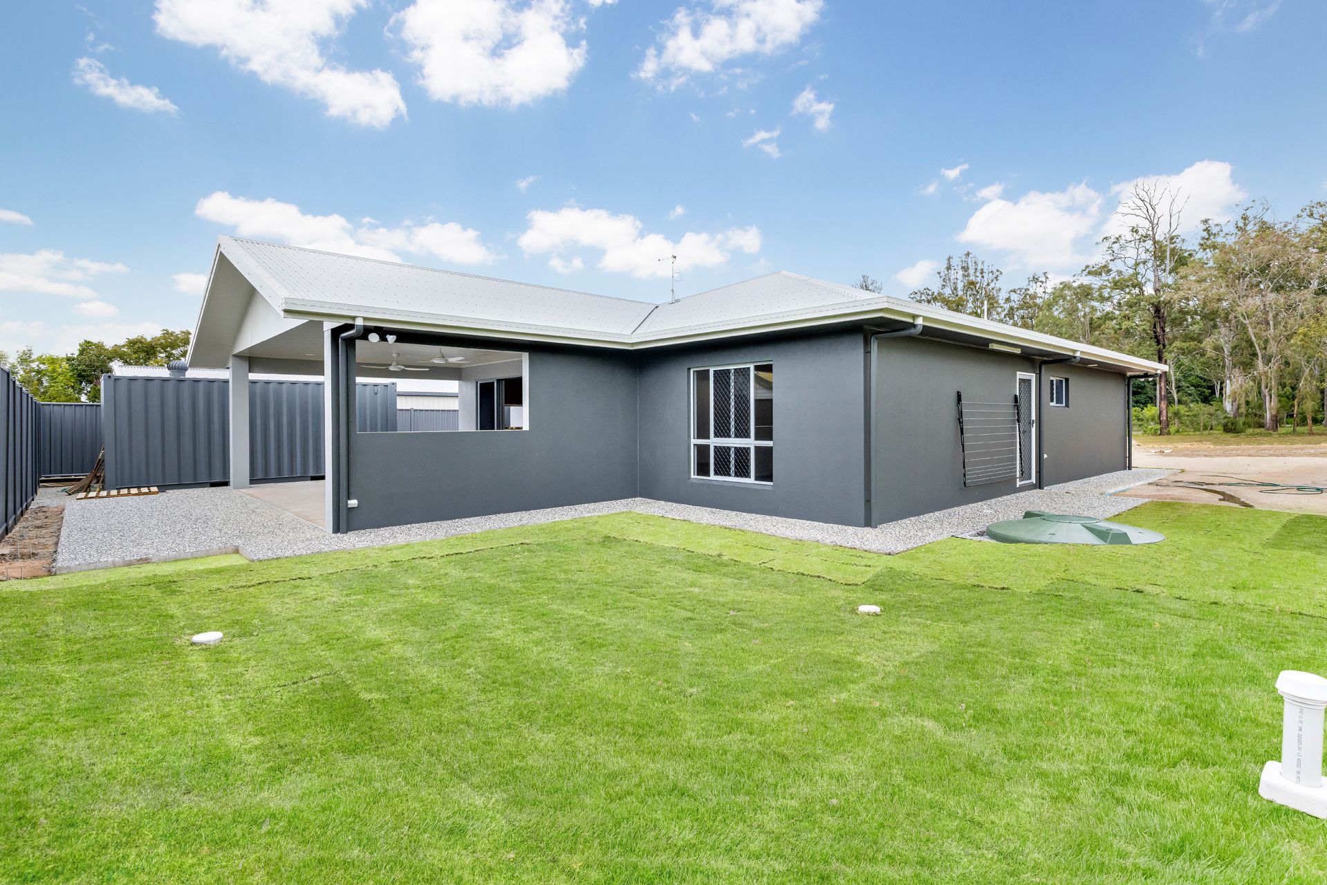 A Modern, Grey Single-story House With a White Roof and Gravel Patio — Ashlee Jones Homes in Gordonvale, QLD