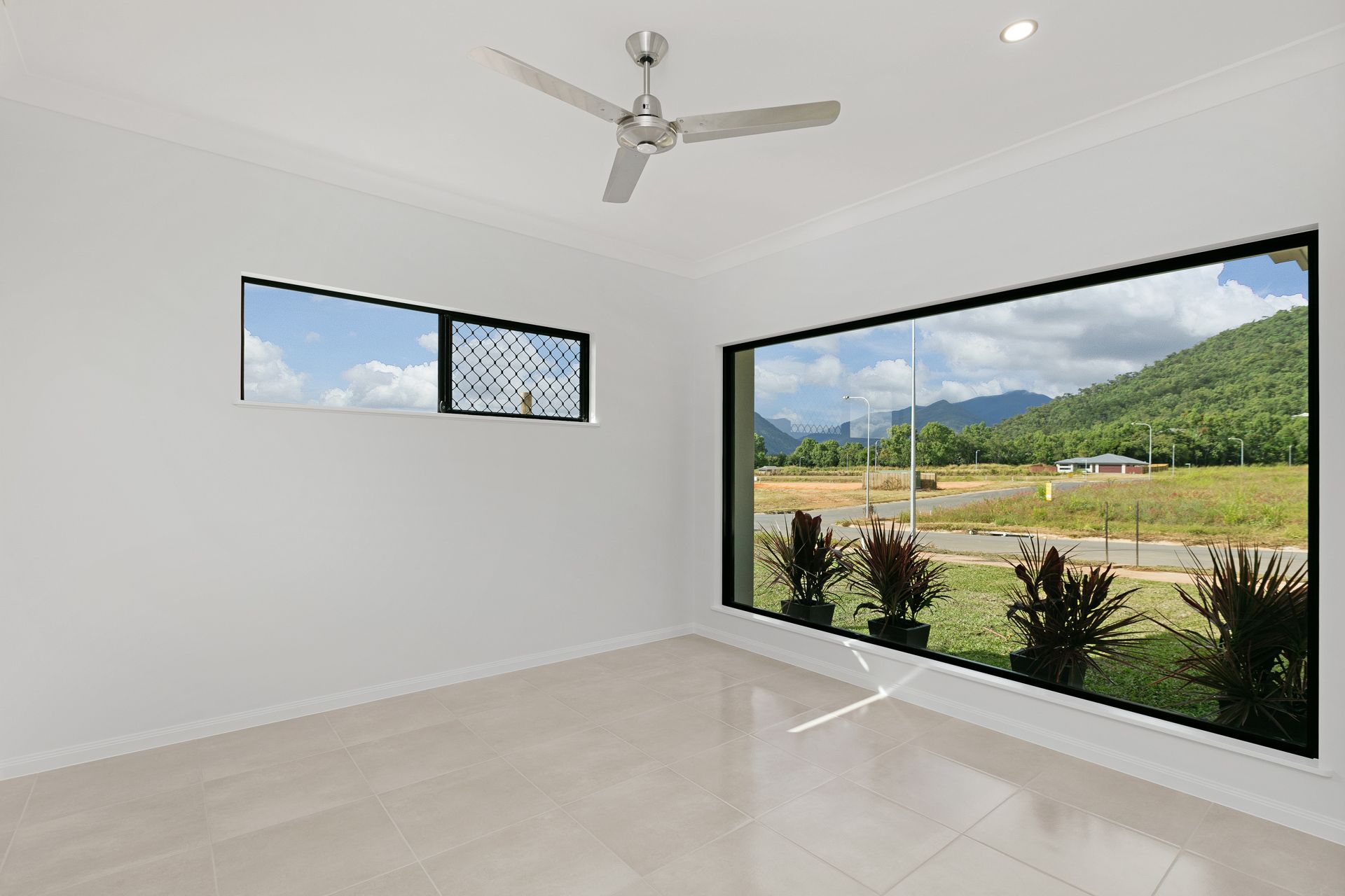 An Empty Room With White Walls, Tiled Floors — Ashlee Jones Homes in Gordonvale, QLD