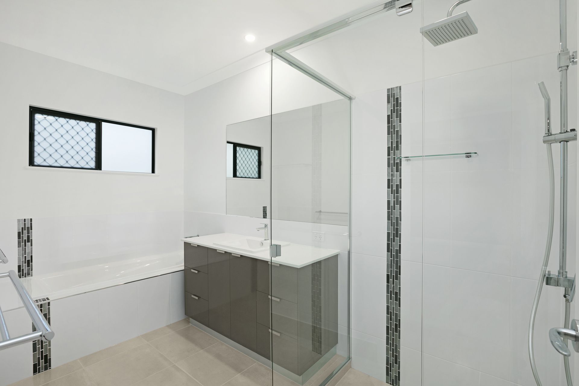 Modern Bathroom With a White Bathtub, a Glossy Grey Vanity Cabinet — Ashlee Jones Homes in Gordonvale, QLD