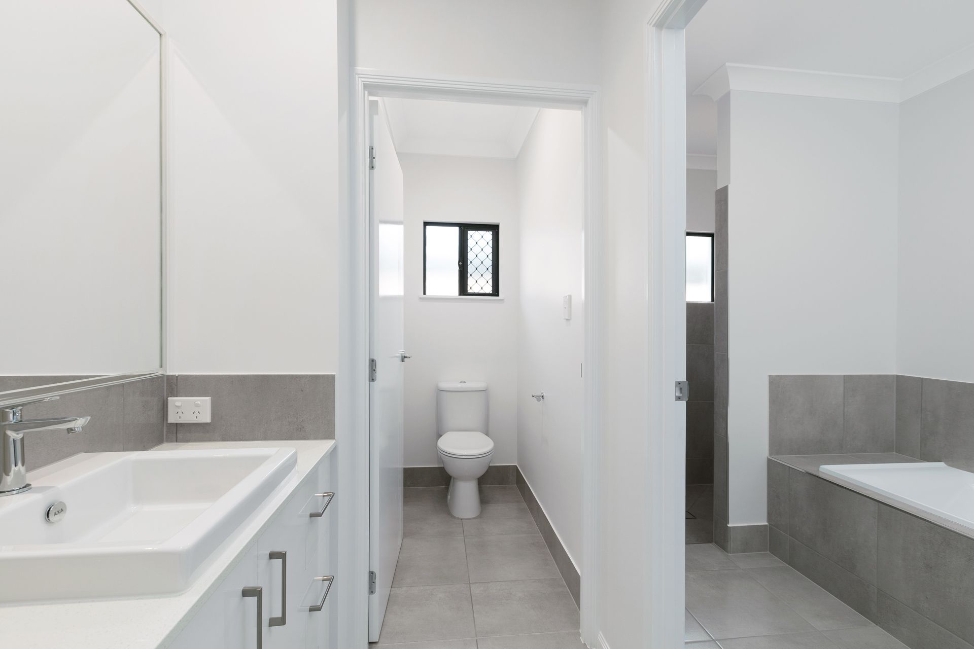 A Modern Bathroom With a White Vanity Sink — Ashlee Jones Homes in Gordonvale, QLD
