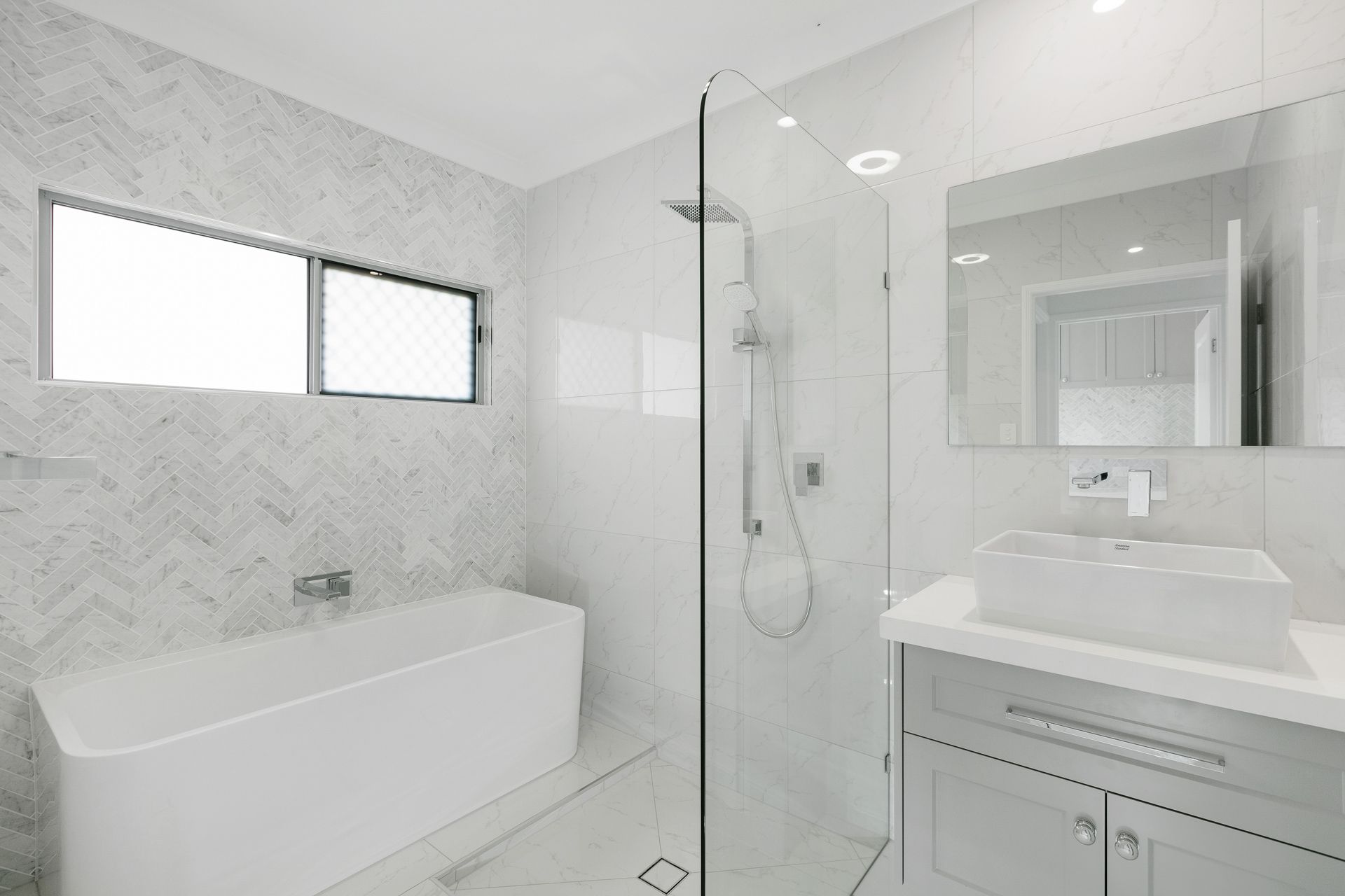 A Modern Bathroom Featuring a White Bathtub — Ashlee Jones Homes in Gordonvale, QLD
